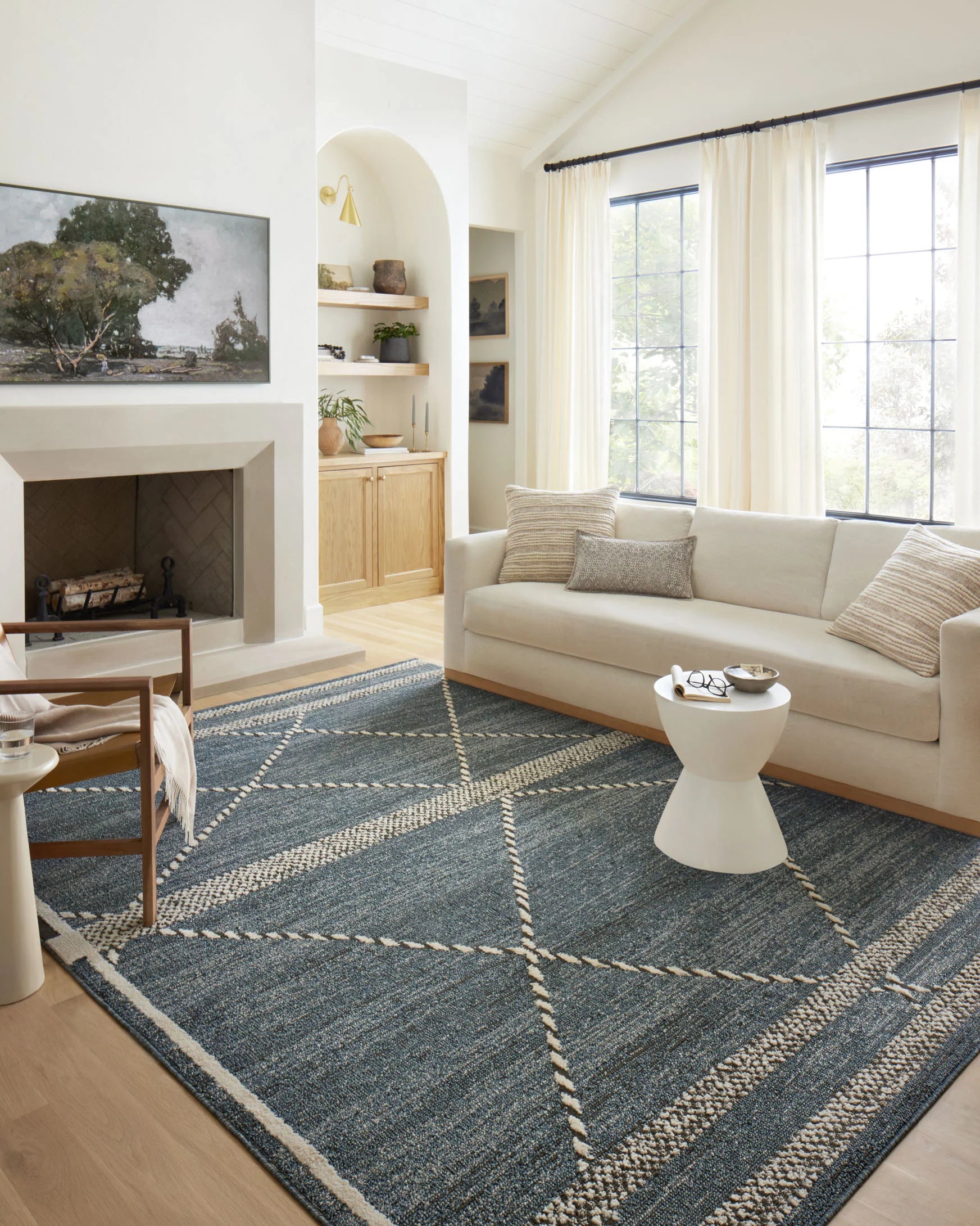 Transitional area rug in living room with blue-gray tone, cream diamond pattern, textured weave.