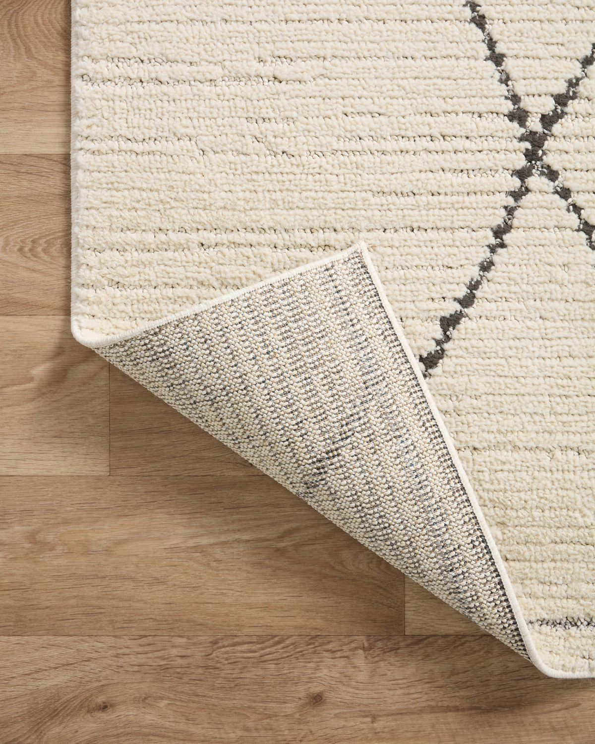 Ivory runner rug edge with charcoal lattice; low-pile woven border visible