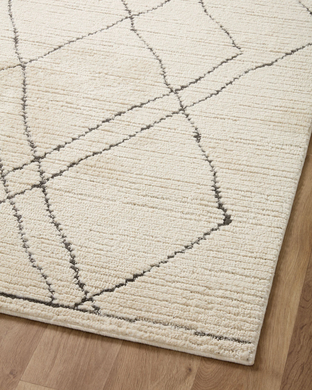 Ivory and charcoal area rug with diamond trellis pattern in stitched lines