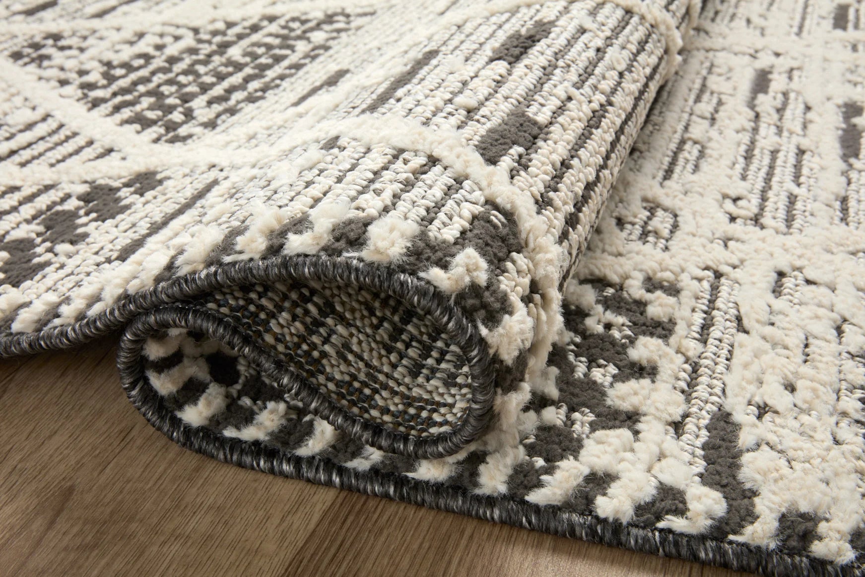 Close-up of charcoal and ivory area rug fringe with textured loop pile