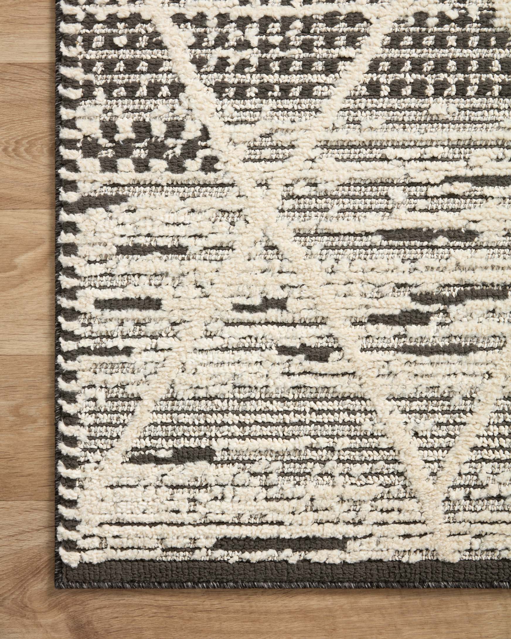 Ivory and charcoal geometric area rug with distressed stripes and small medallion details