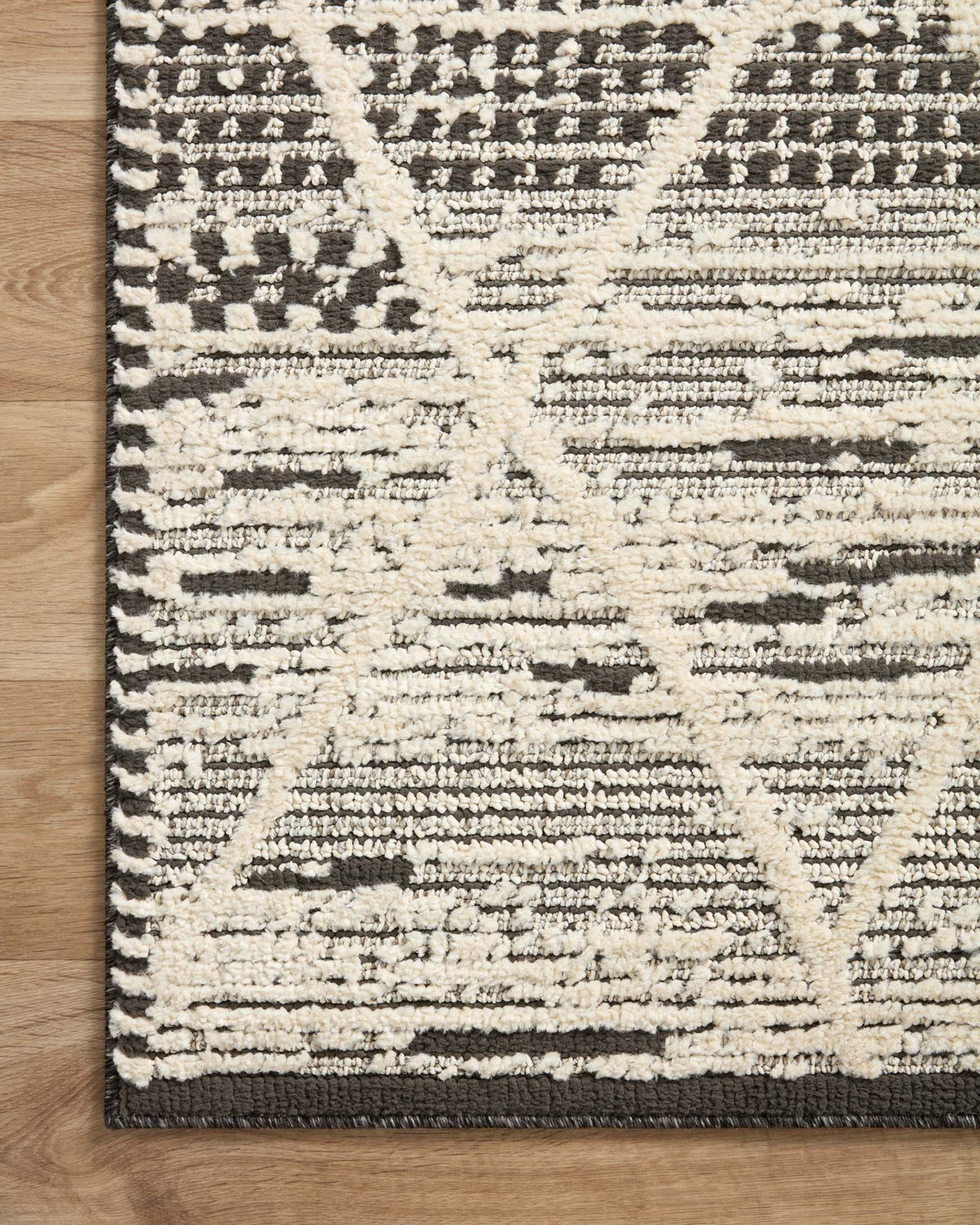 Charcoal and ivory accent rug with geometric blocks and stitched fringed border