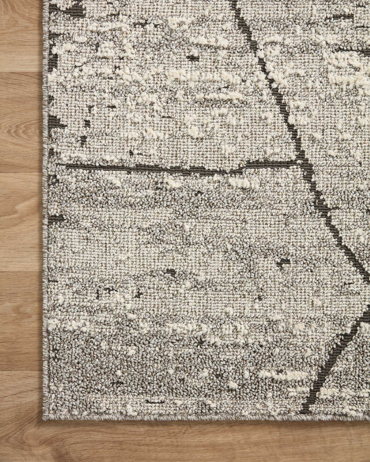 Grey and charcoal geometric rug with distressed lines and low, looped weave texture