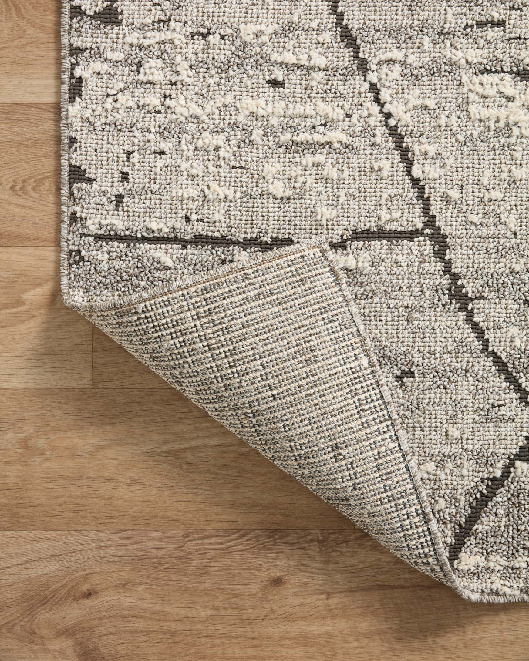 Grey geometric runner rug with stitched trim and textured weave visible