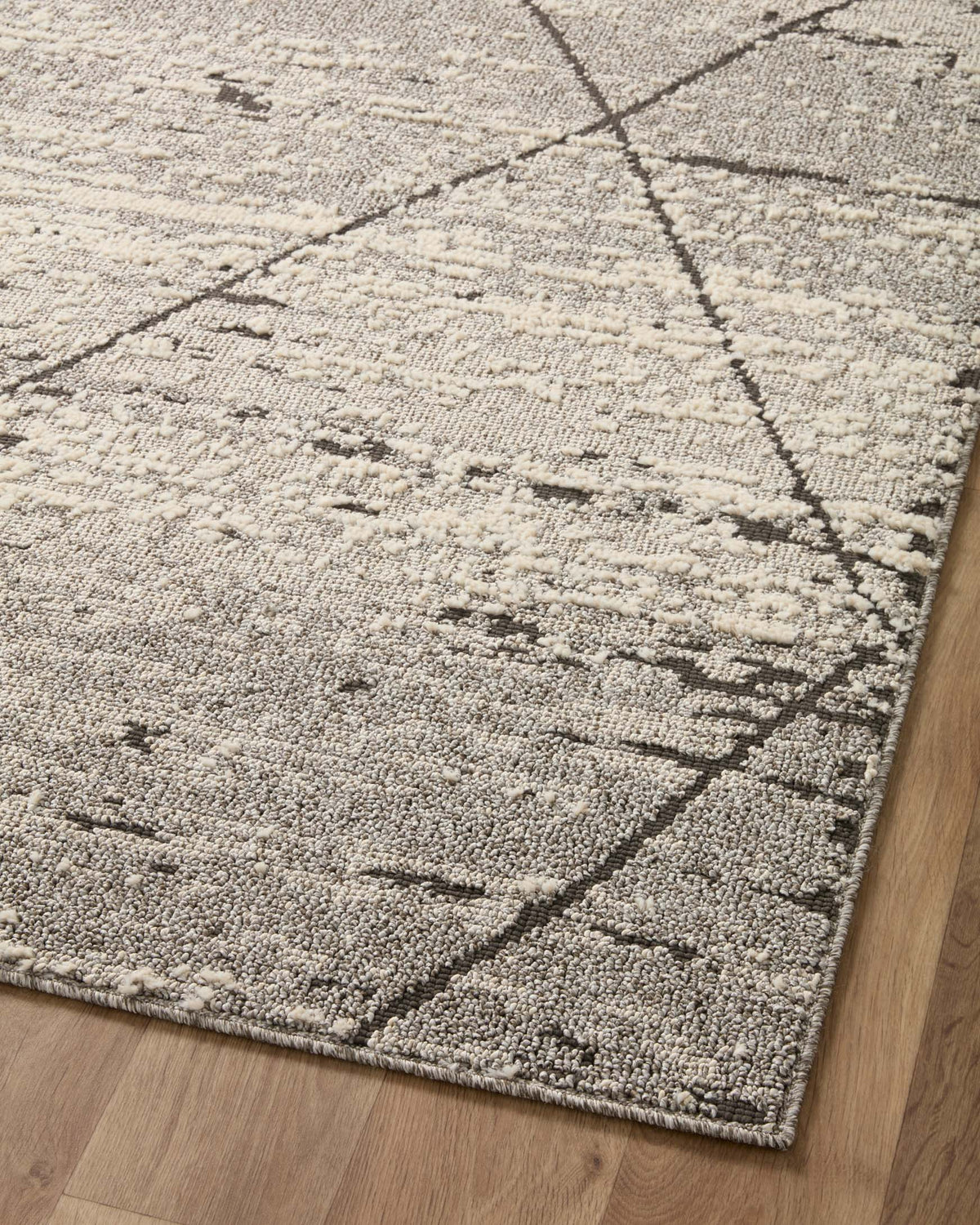 Grey geometric runner rug with crosshatched pattern and low, speckled pile