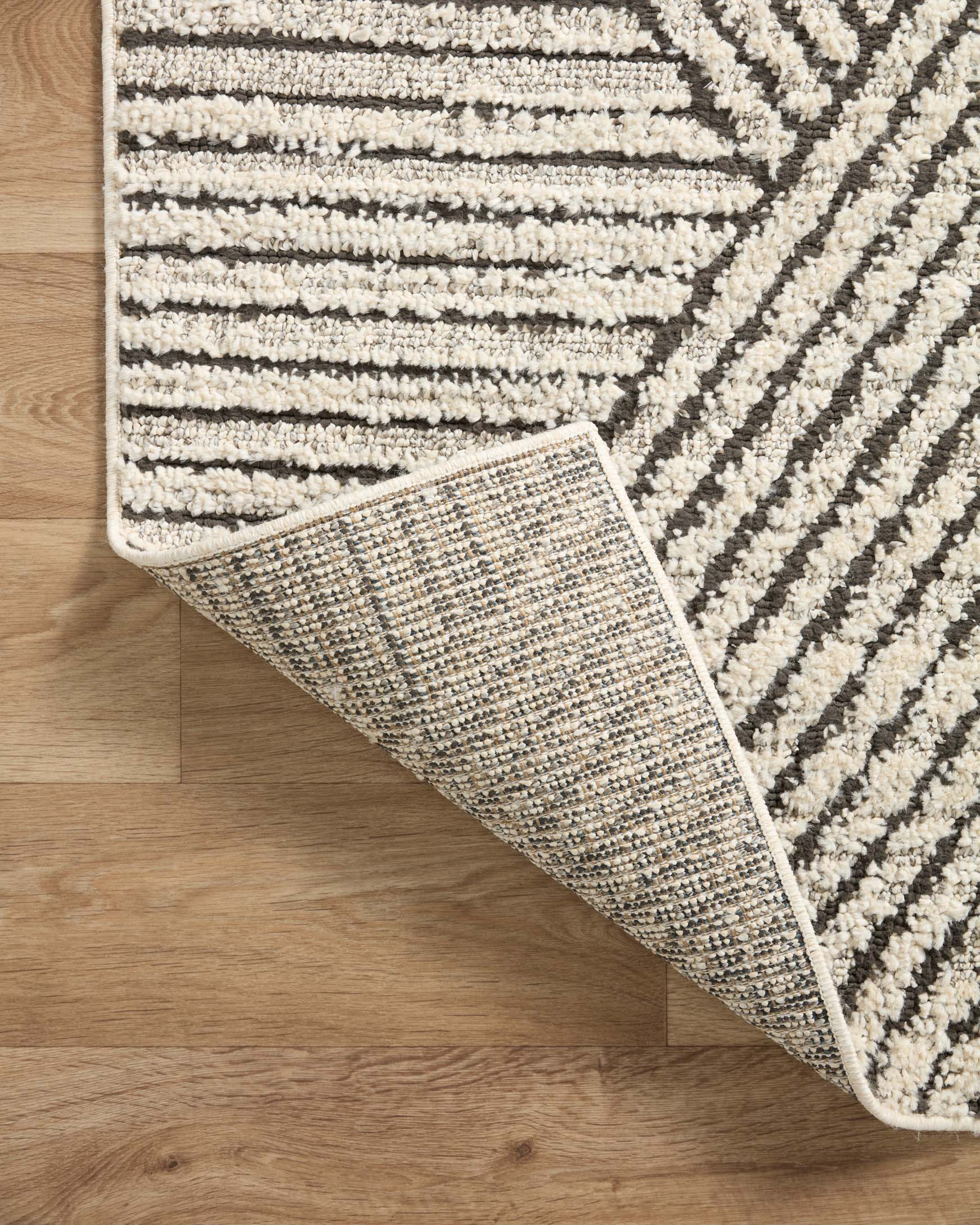 Ivory and charcoal area rug corner with reversible-looking textured border and weave.
