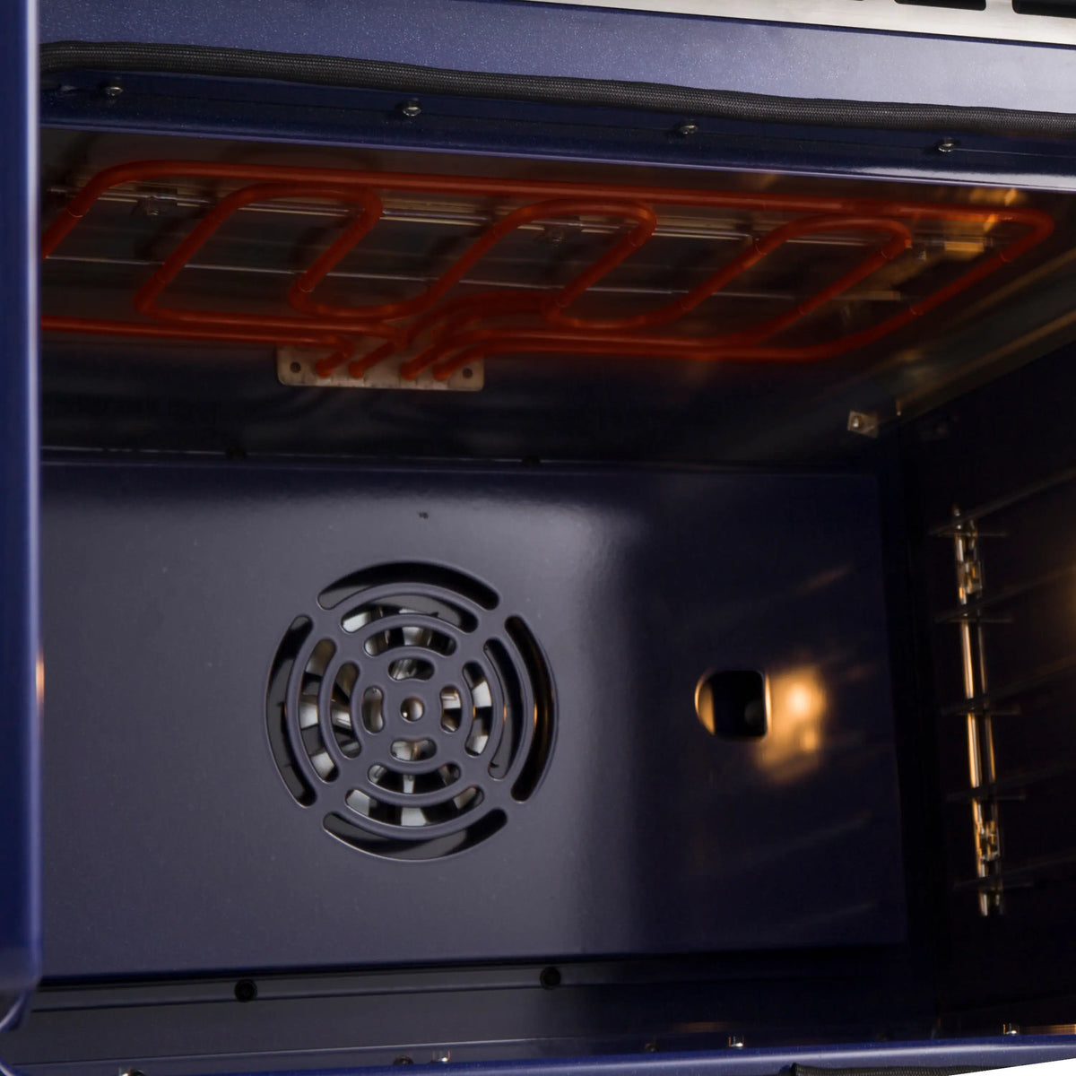 Interior view showing fan vent and glowing heating elements above oven cavity