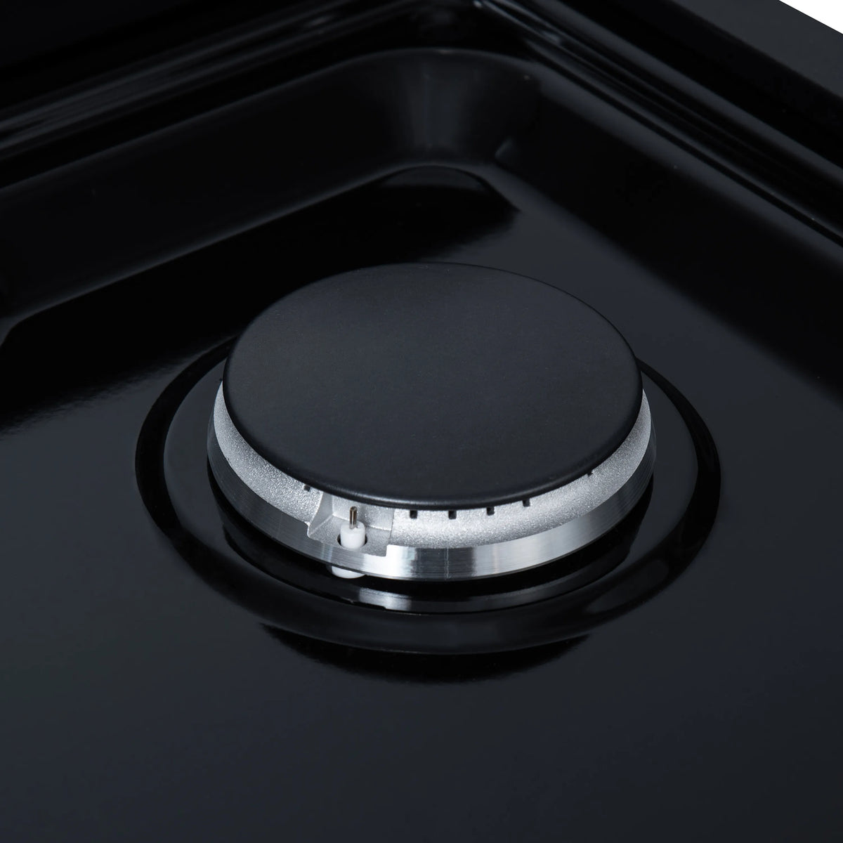 Black sealed gas burner with round cap and surrounding cooktop grate