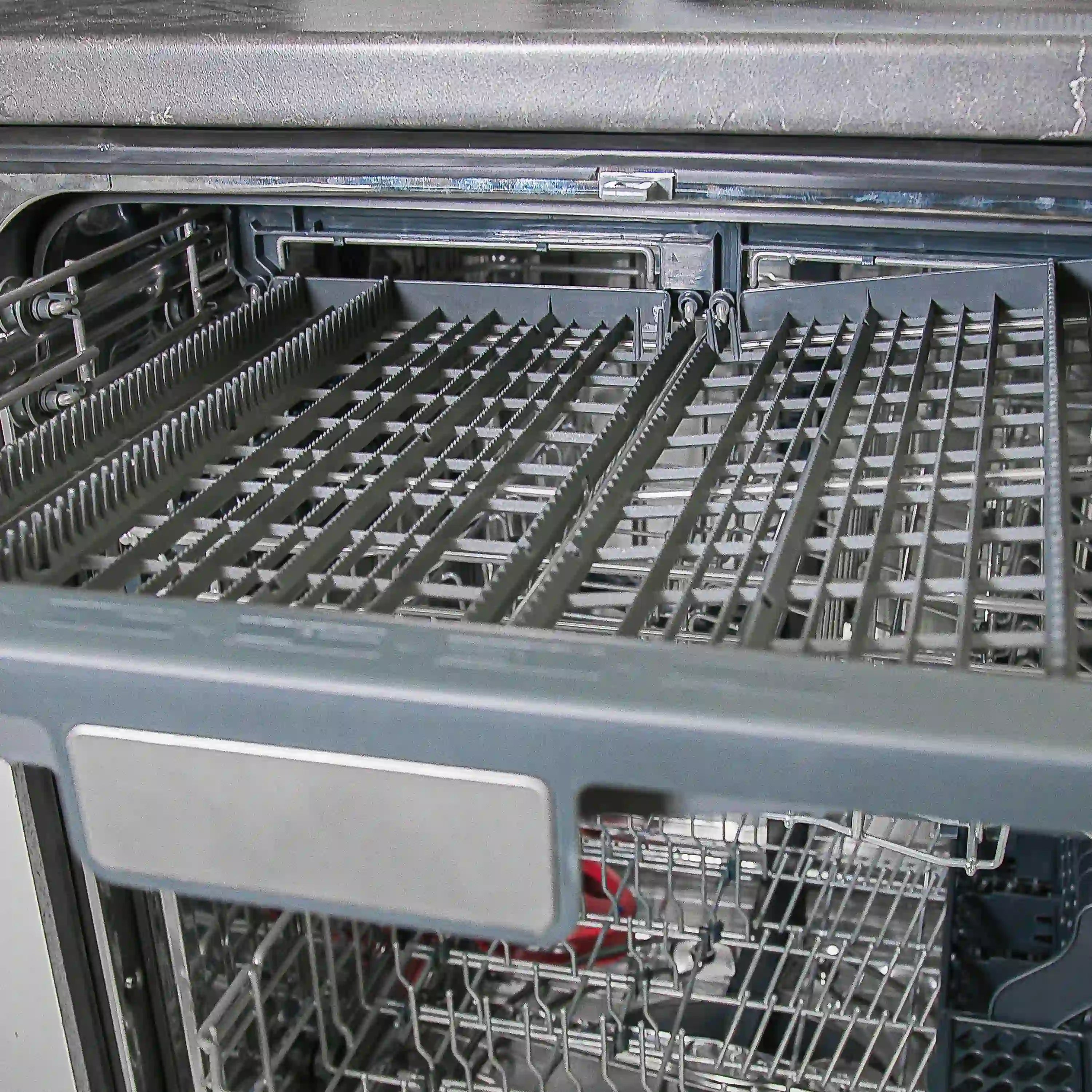 Stainless steel dishwasher rack with fold-down tines and loaded dishware racks