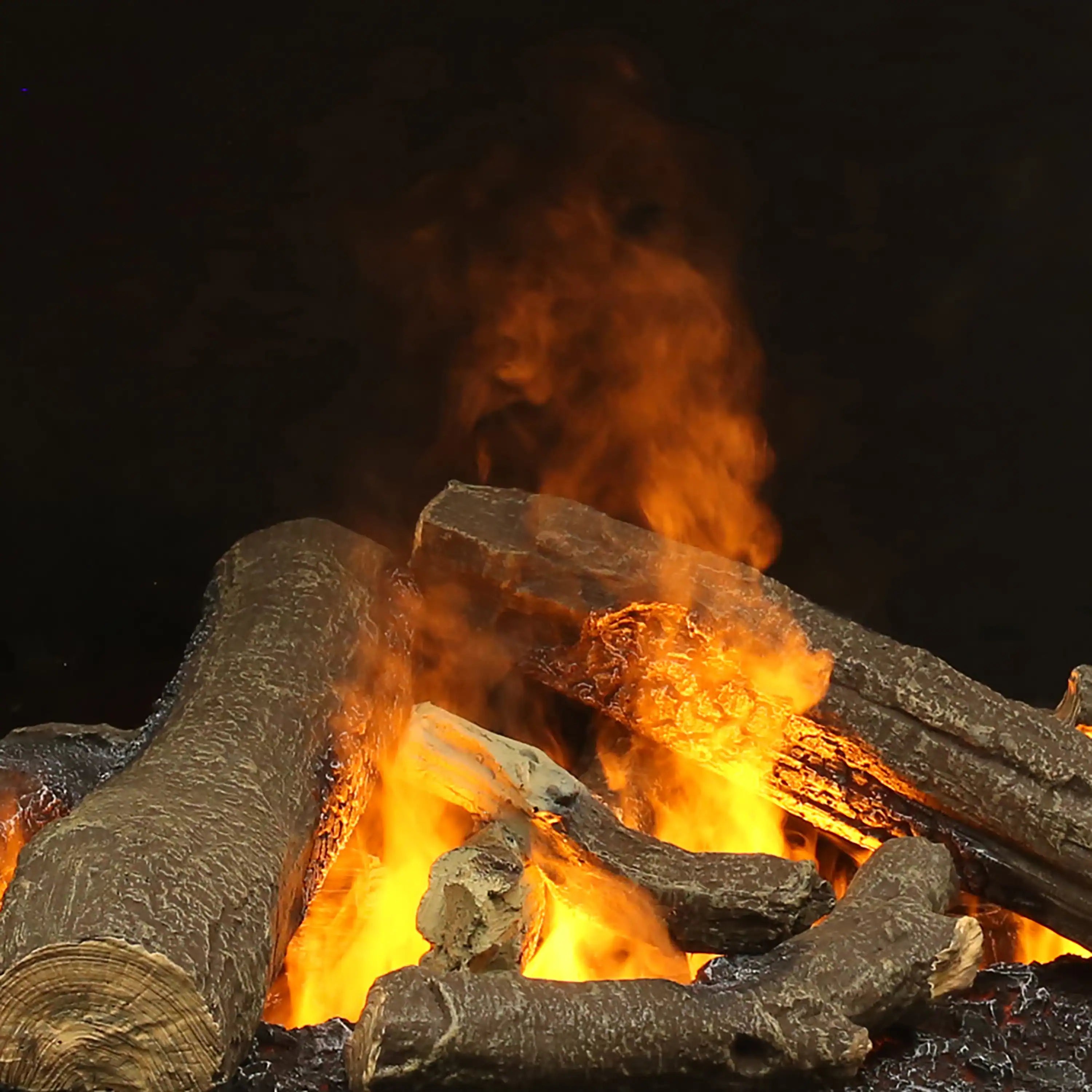 Close-up of faux logs with bright orange flame effect inside an electric firebox