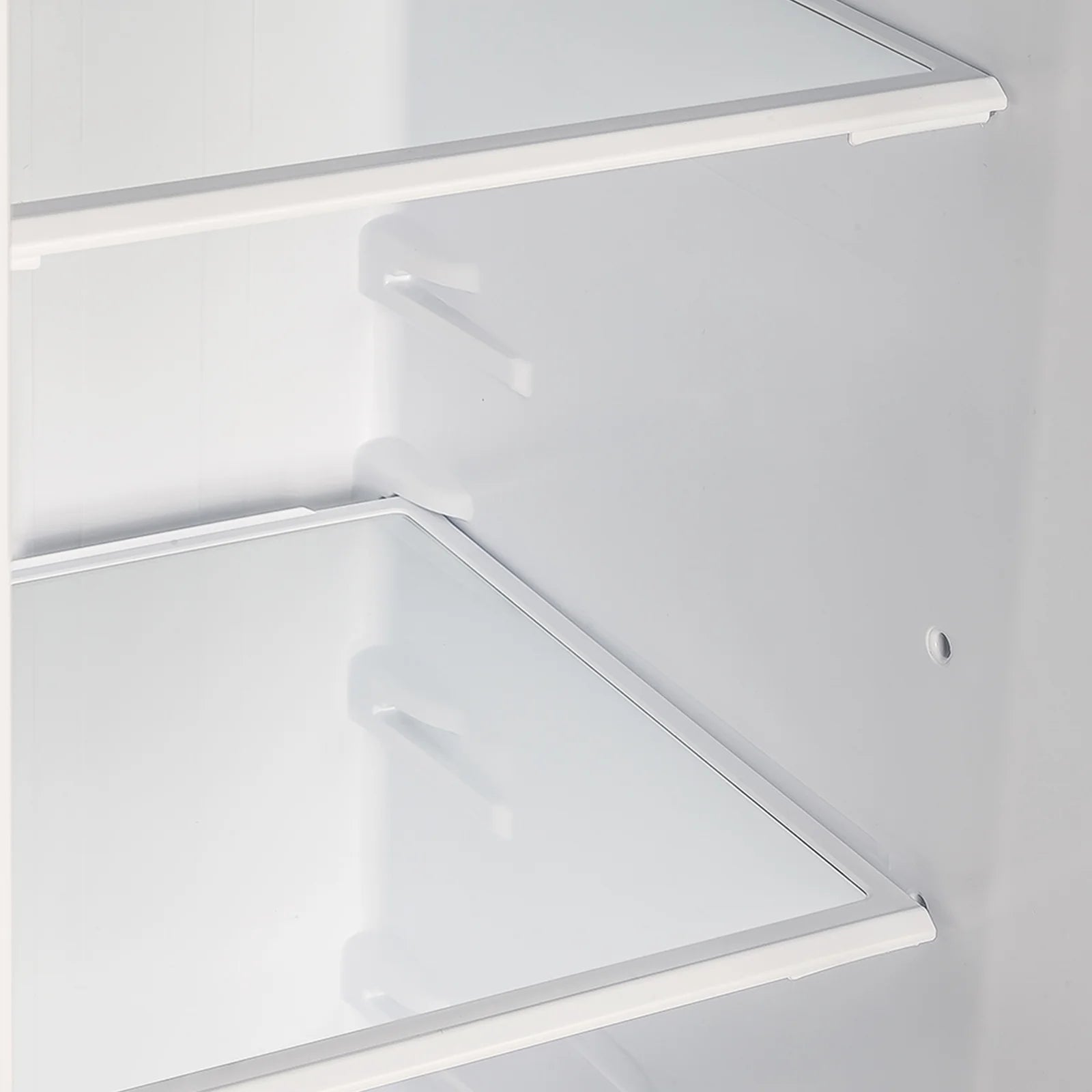 Refrigerator freezer interior with slanted shelves and white side walls