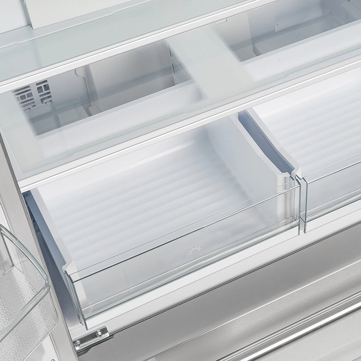 Refrigerator interior with top shelves and clear drawer bins on the main compartment.