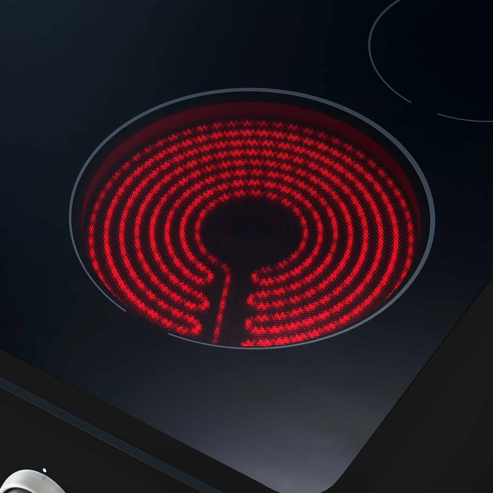 Black electric range cooktop with red coil burner turned on