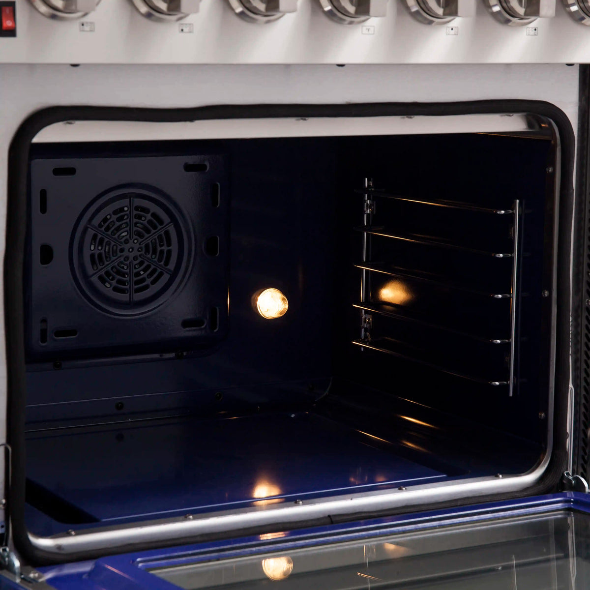 Open oven cavity with racks, round fan vent, and warm interior light