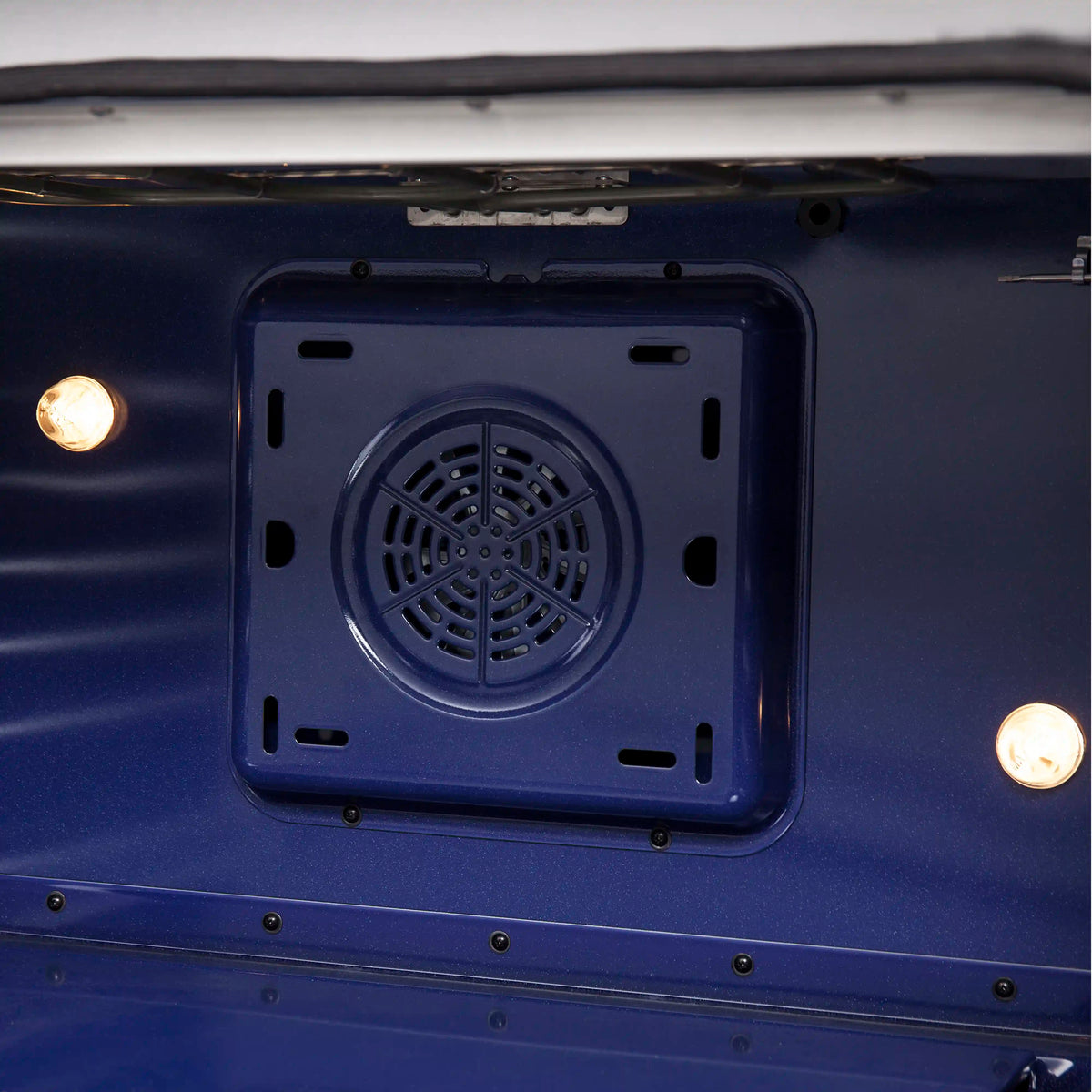 Oven bottom ventilation cover with fan-style grille inside electric range