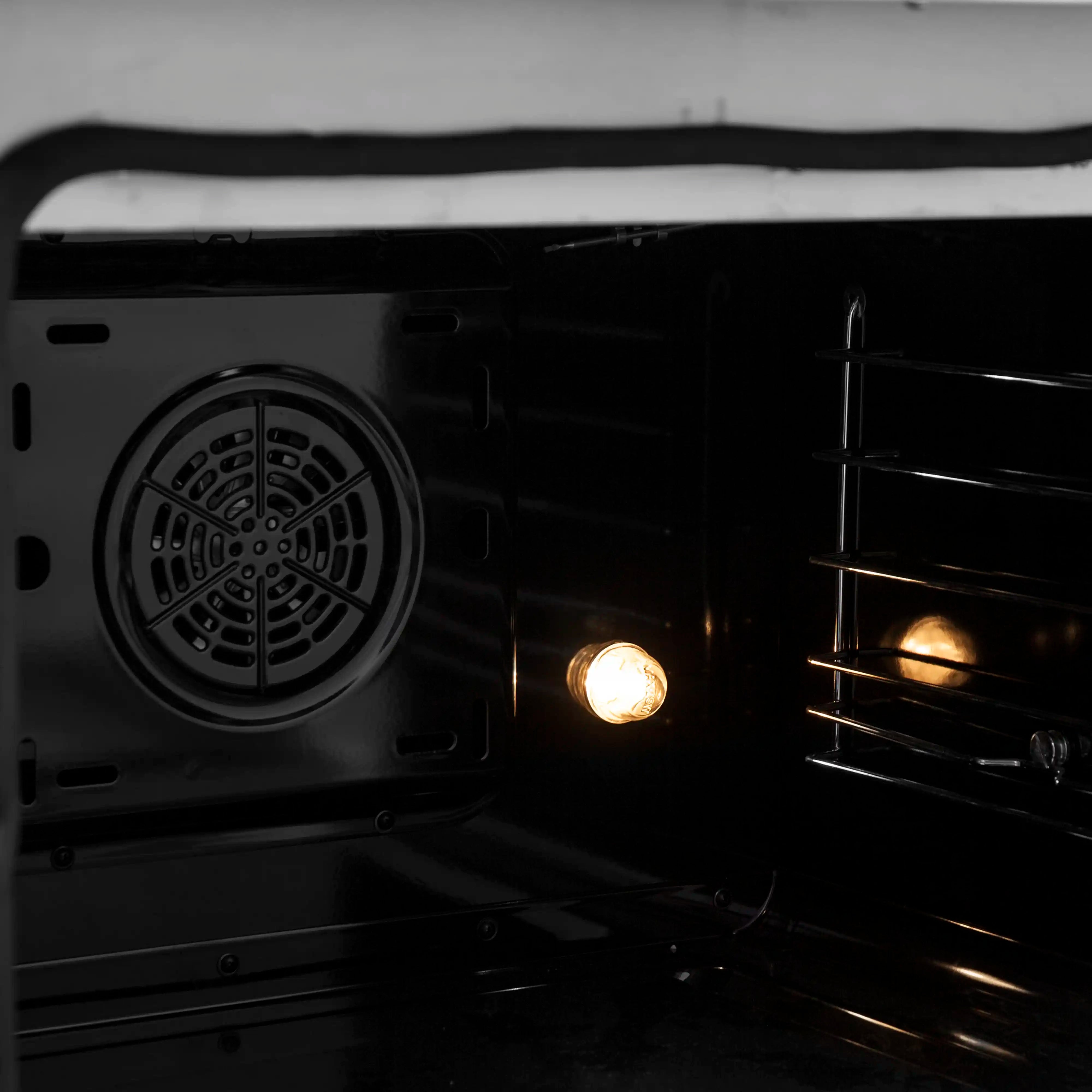 Forno electric oven interior with round convection fan vent and lit oven bulbs