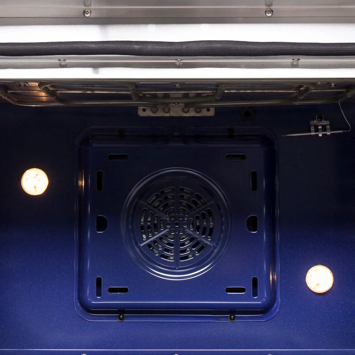 Electric oven interior with circular vent fan opening at the base and side lights
