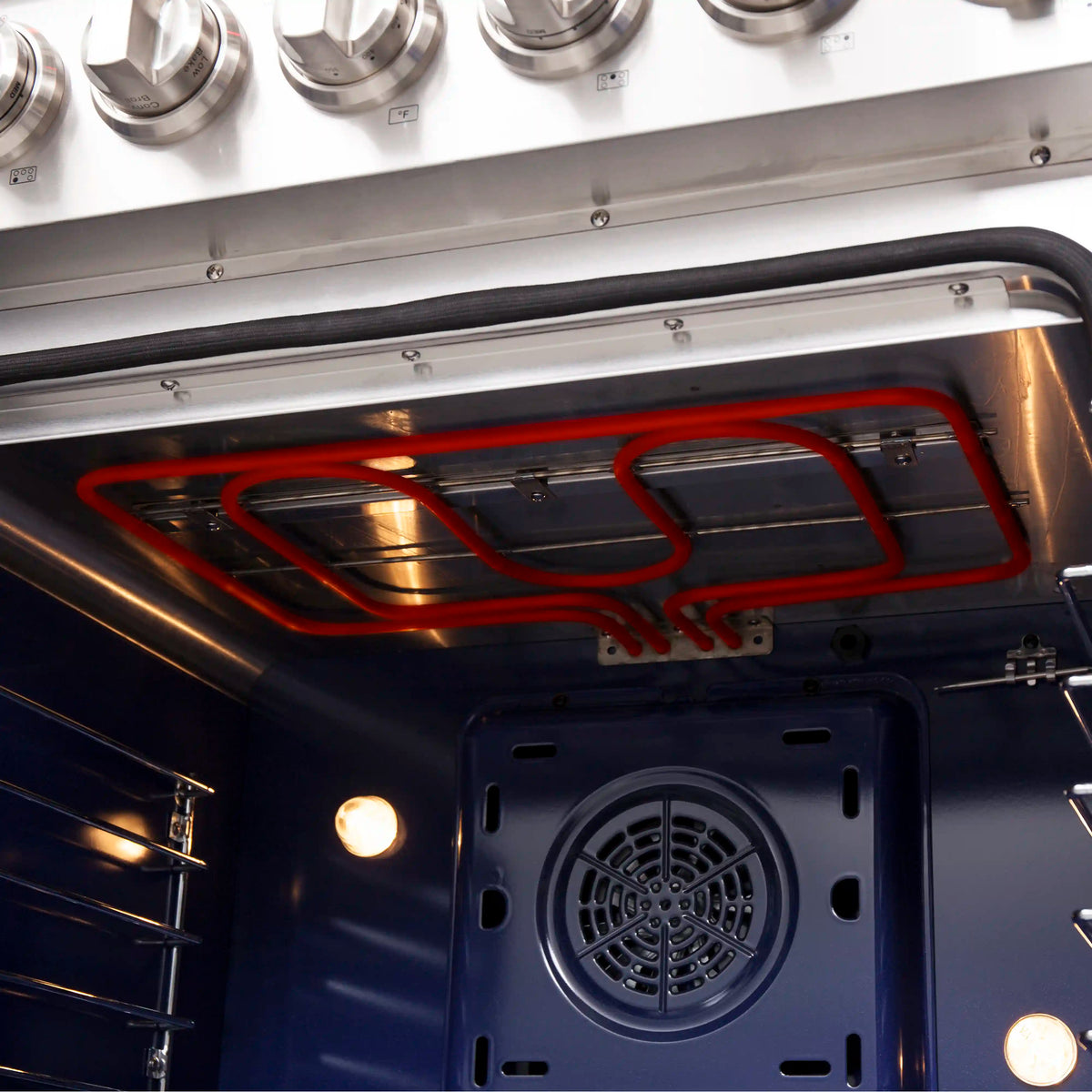 Electric oven bottom view showing red heating element and circular vent fan opening
