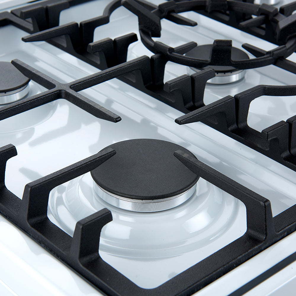 Close-up of white gas range cooktop burner caps with black grates