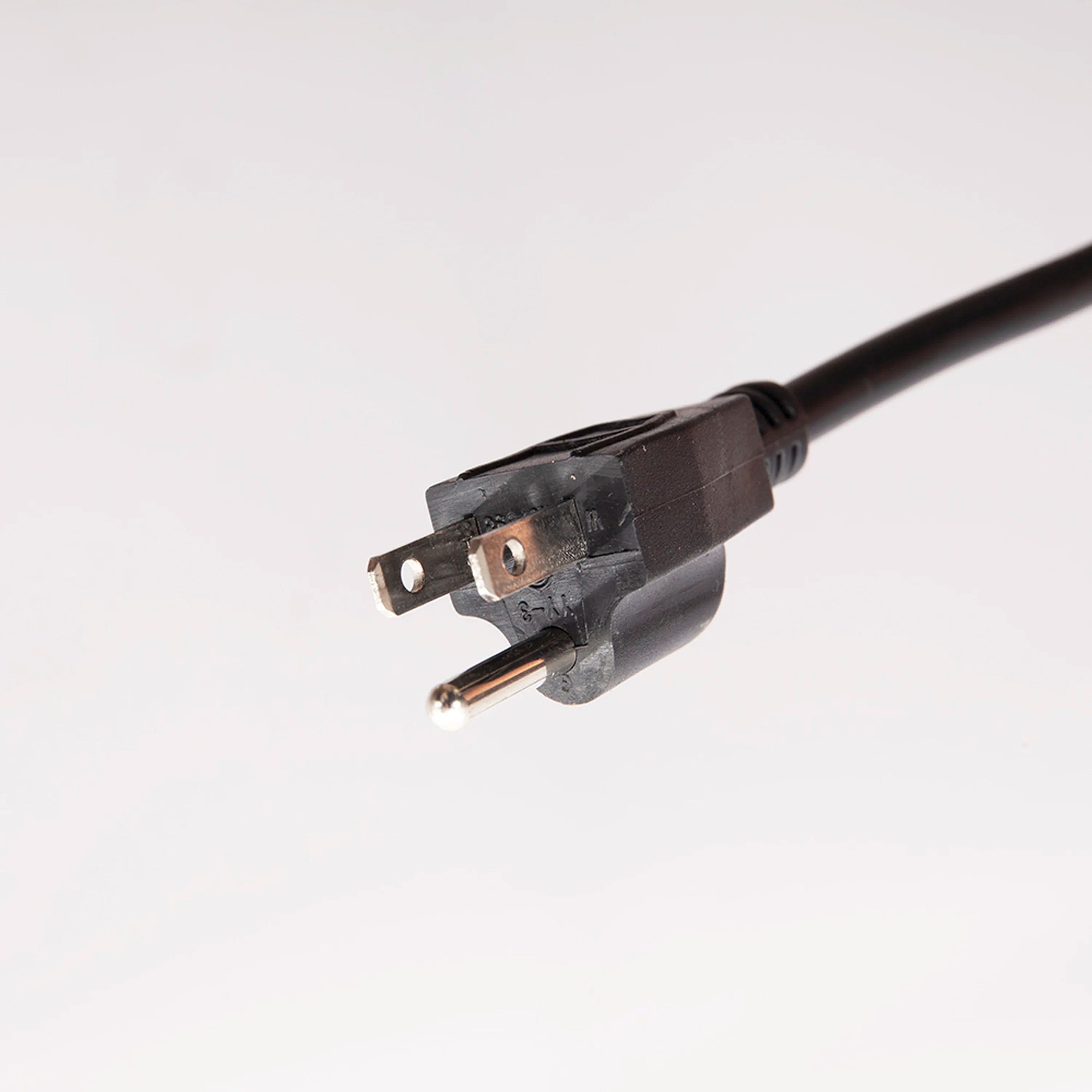Three-prong power plug on a black power cord