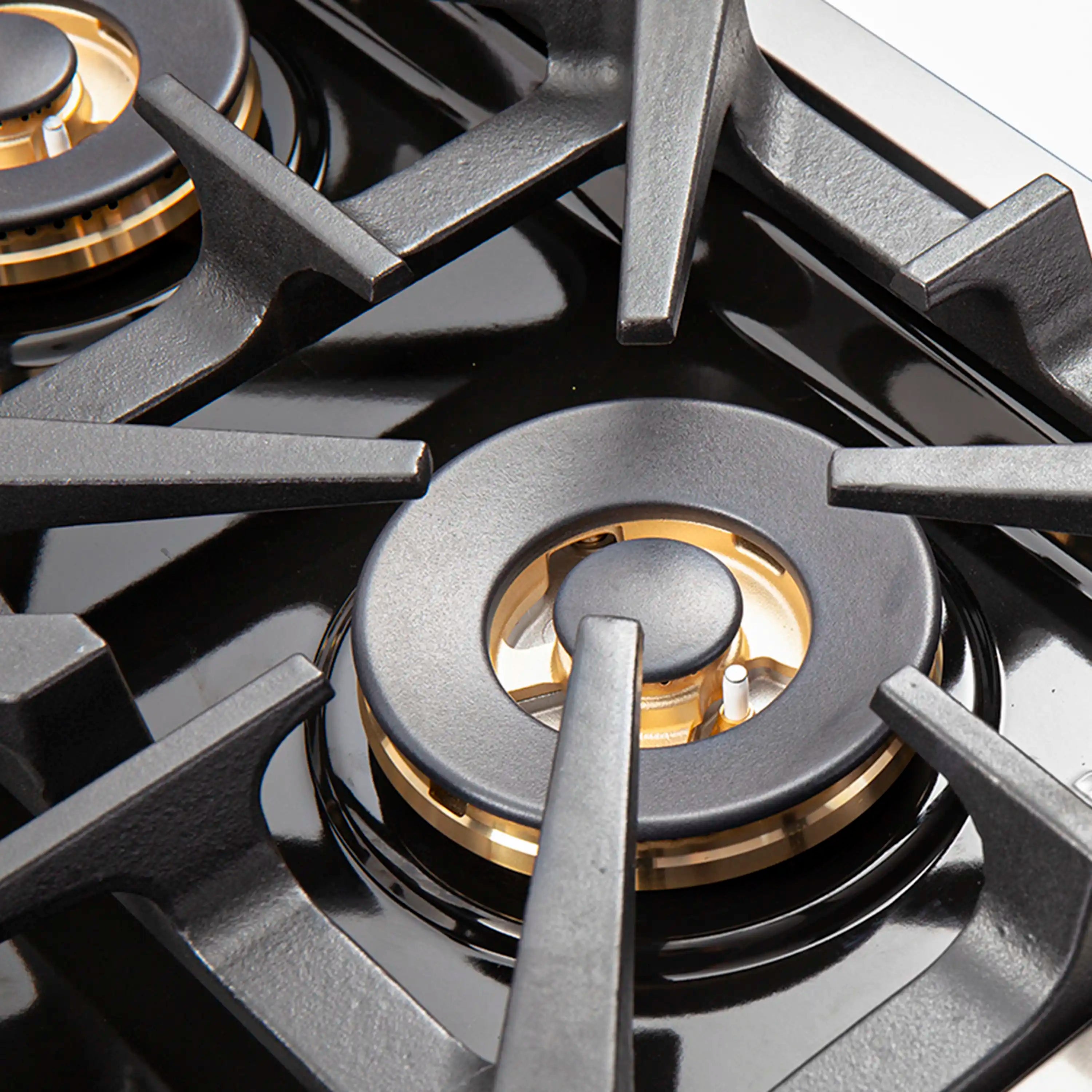 Stainless steel gas cooktop burner with black grates and round burner cap