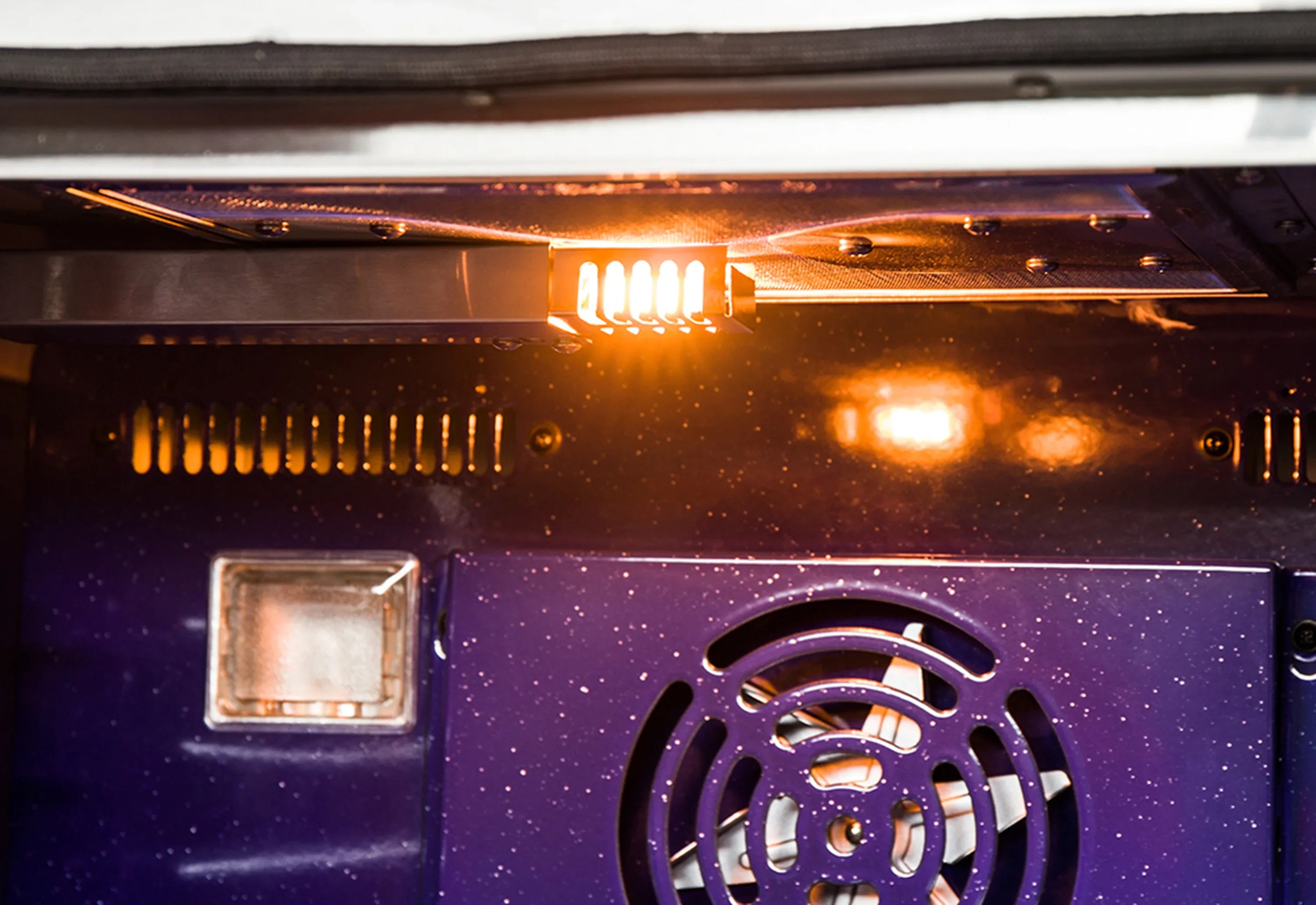 Gas oven interior with heating elements, fan vent, and oven light