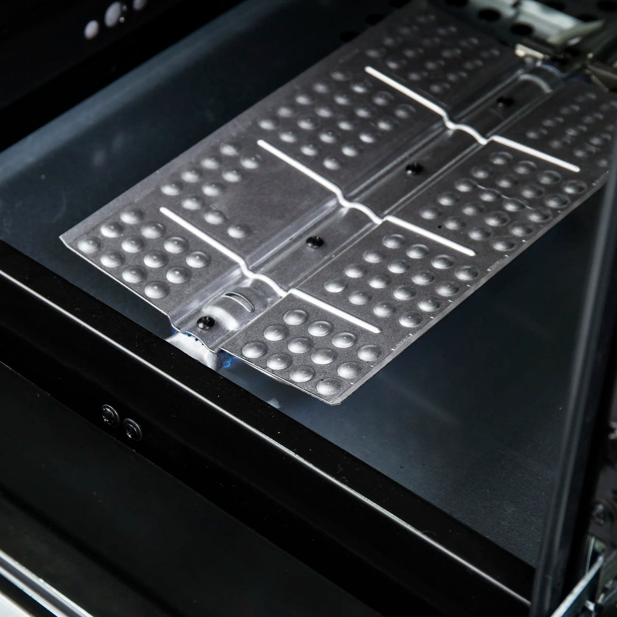 Gas oven broiler tray with perforated warming/baking surface and metal supports.