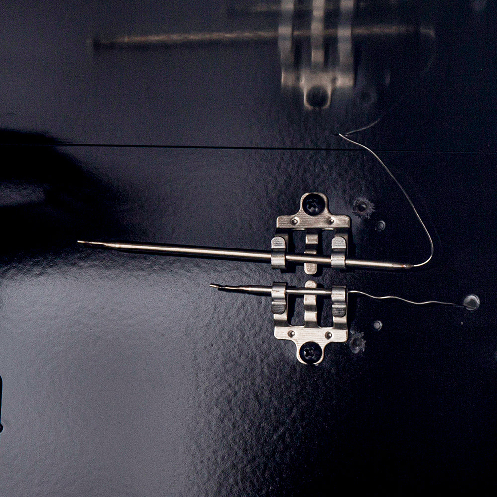Gas range oven igniter assembly with metal bracket and wires on dark oven panel