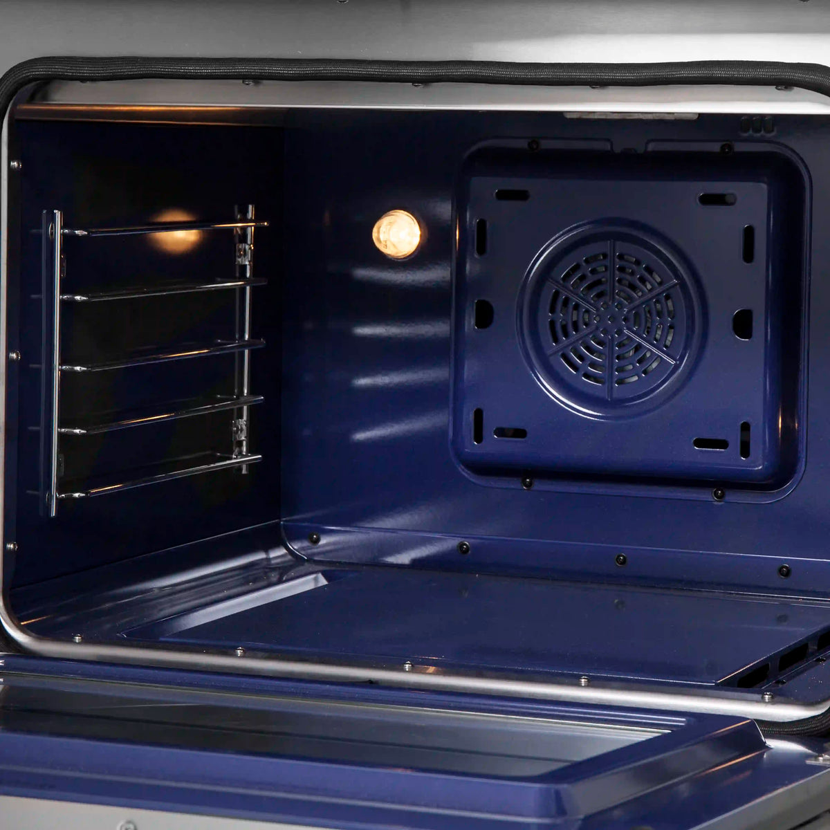 Freestanding dual fuel range oven with racks and bright interior light, blue interior.
