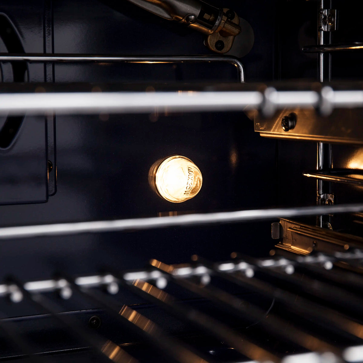 Gas range oven control area with lit oven burner glow and metal tubing