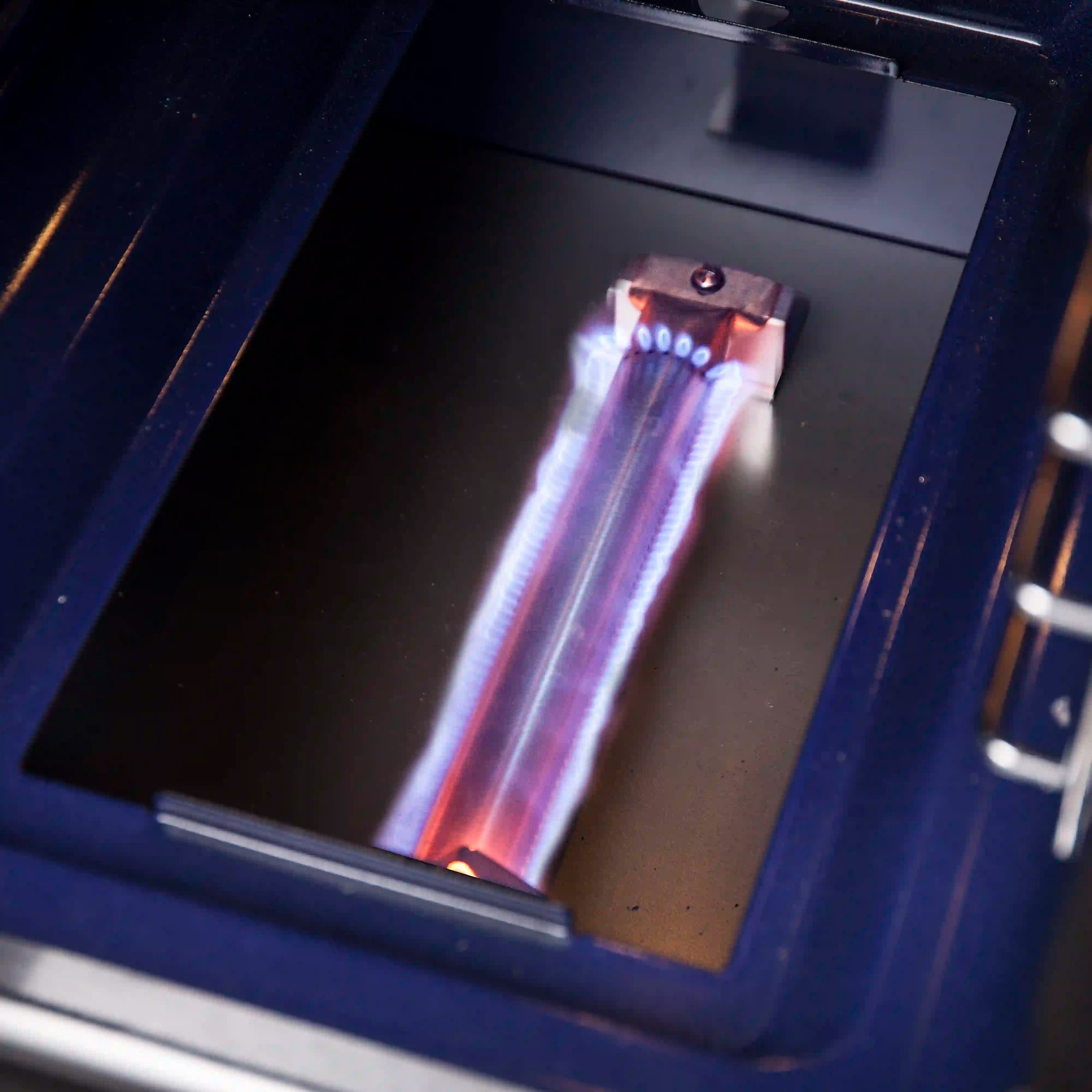 Glowing gas broiler element inside stainless oven cavity
