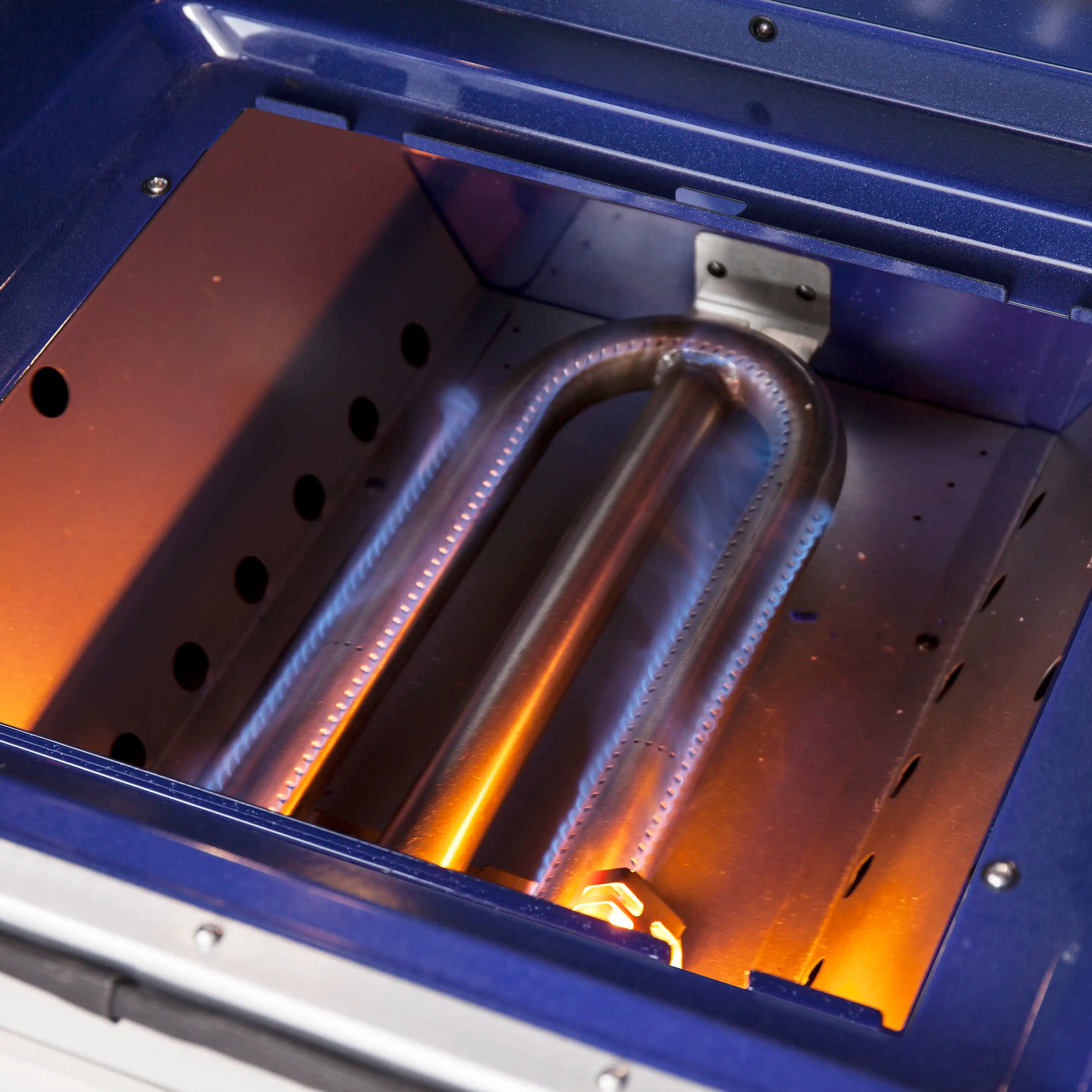 Gas oven broiler area with glowing burners inside the open range
