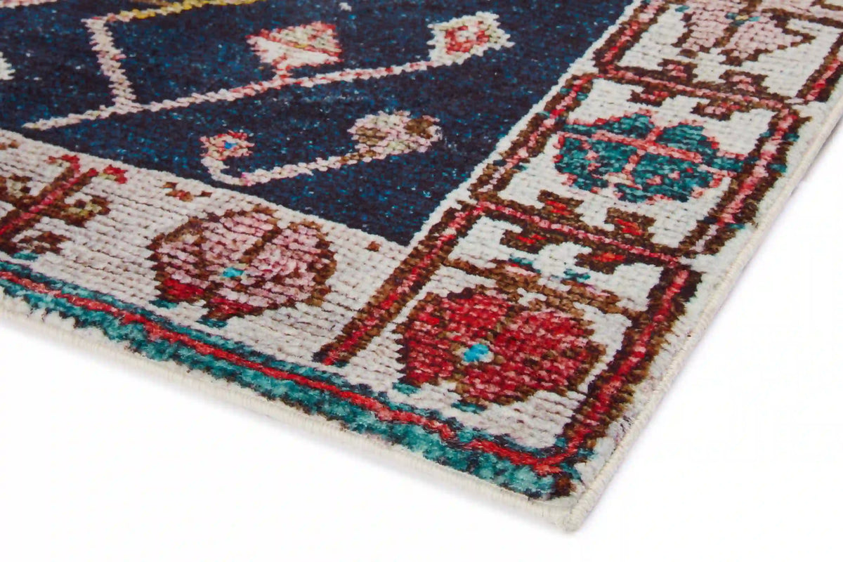 Rectangular multicolor area rug corner with navy center and cream/red geometric motifs