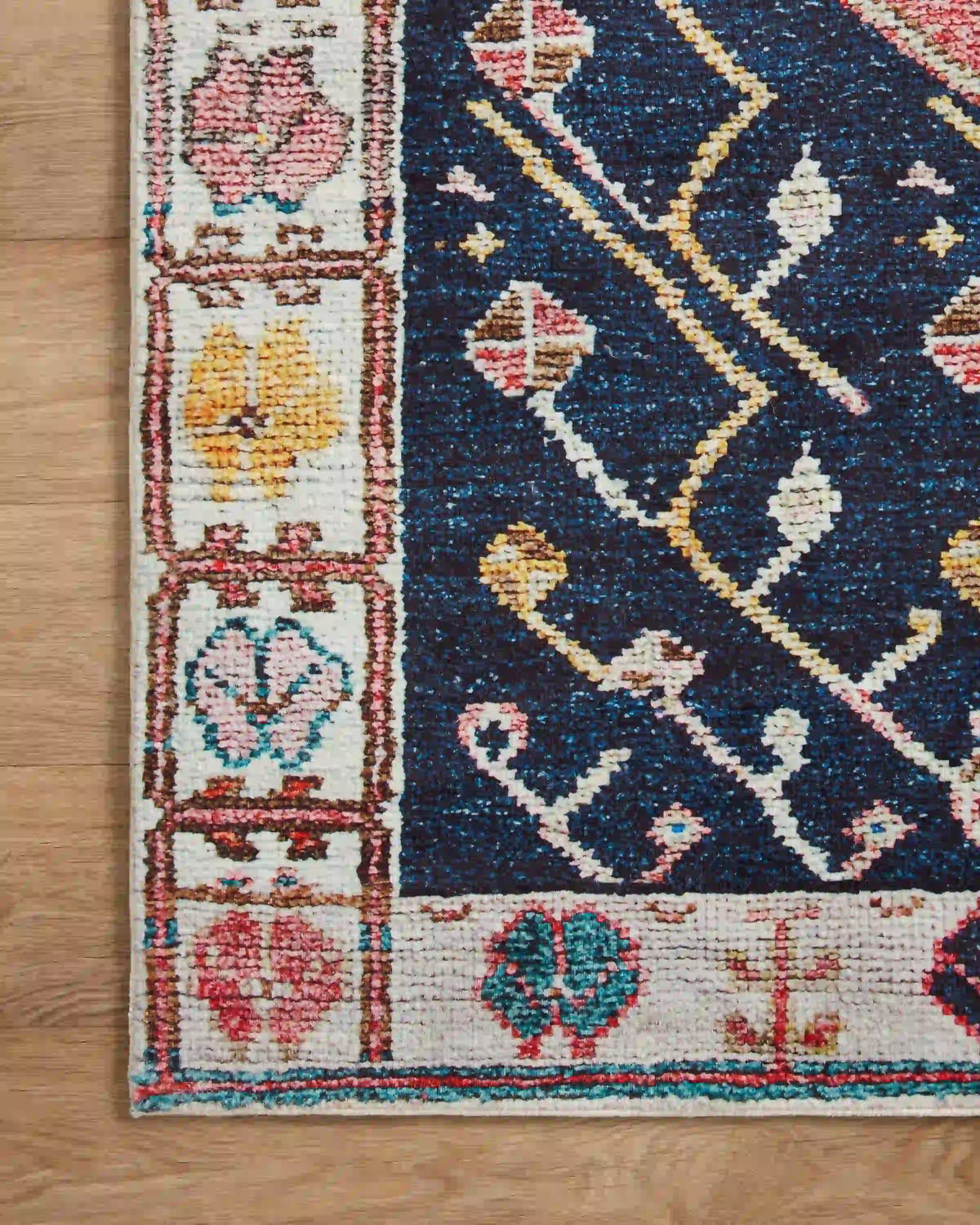 Multicolor patterned area rug with navy field, cream border, and geometric motifs