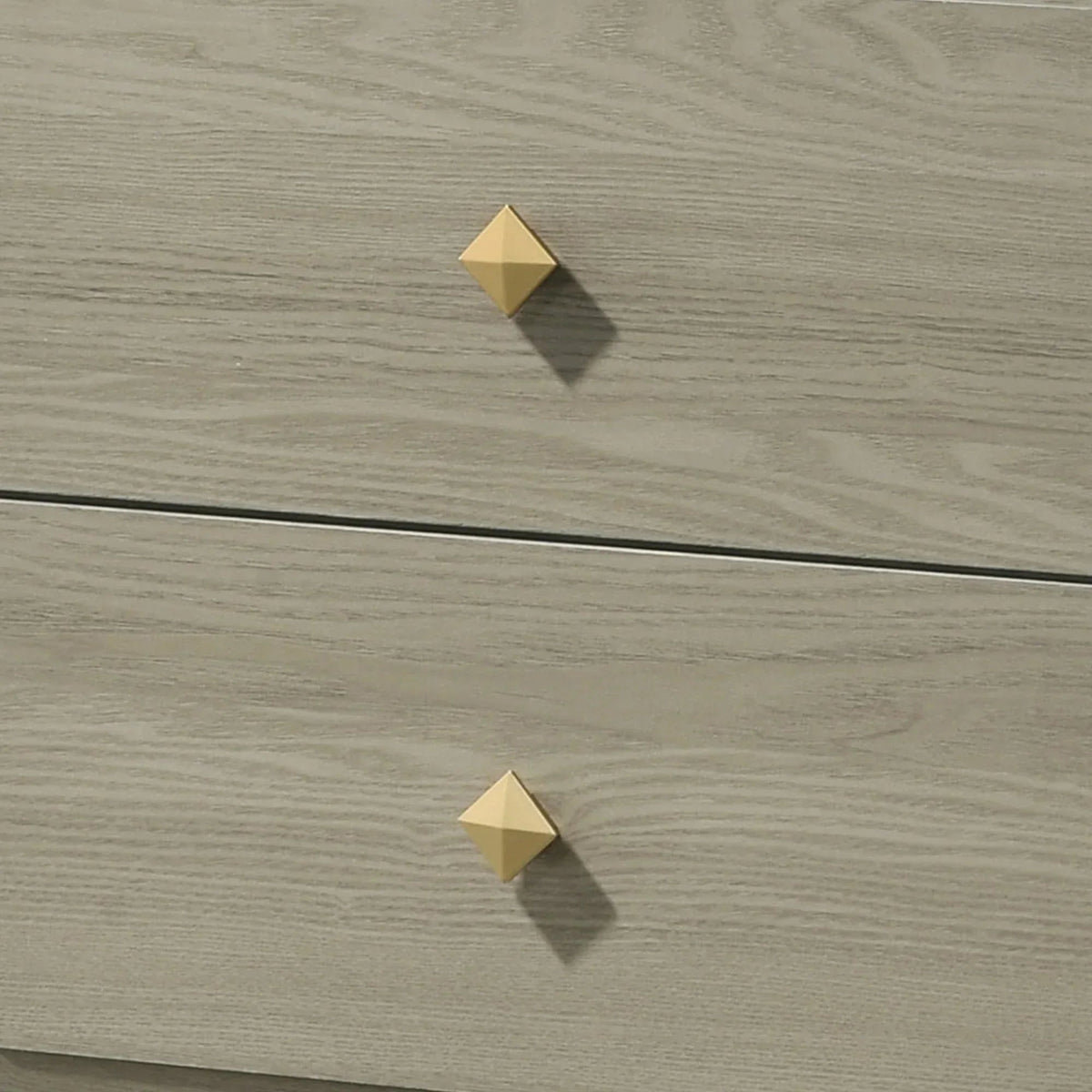 Close-up of gray nightstand drawer fronts with two gold diamond-shaped pulls