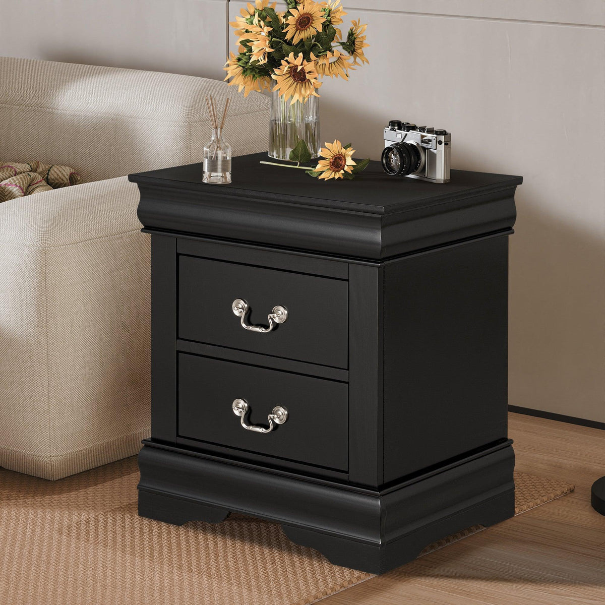 Black night stand with two drawers and curved metal handles, decorative molded sides