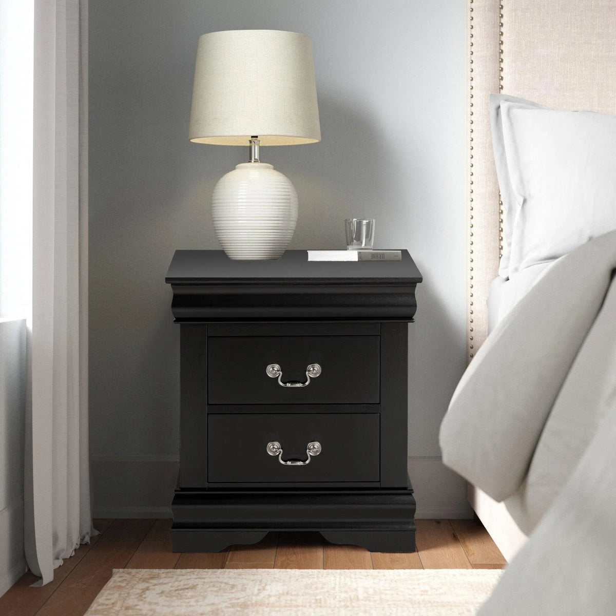 Black night stand with two drawers and curved silver handles, stepped base detail