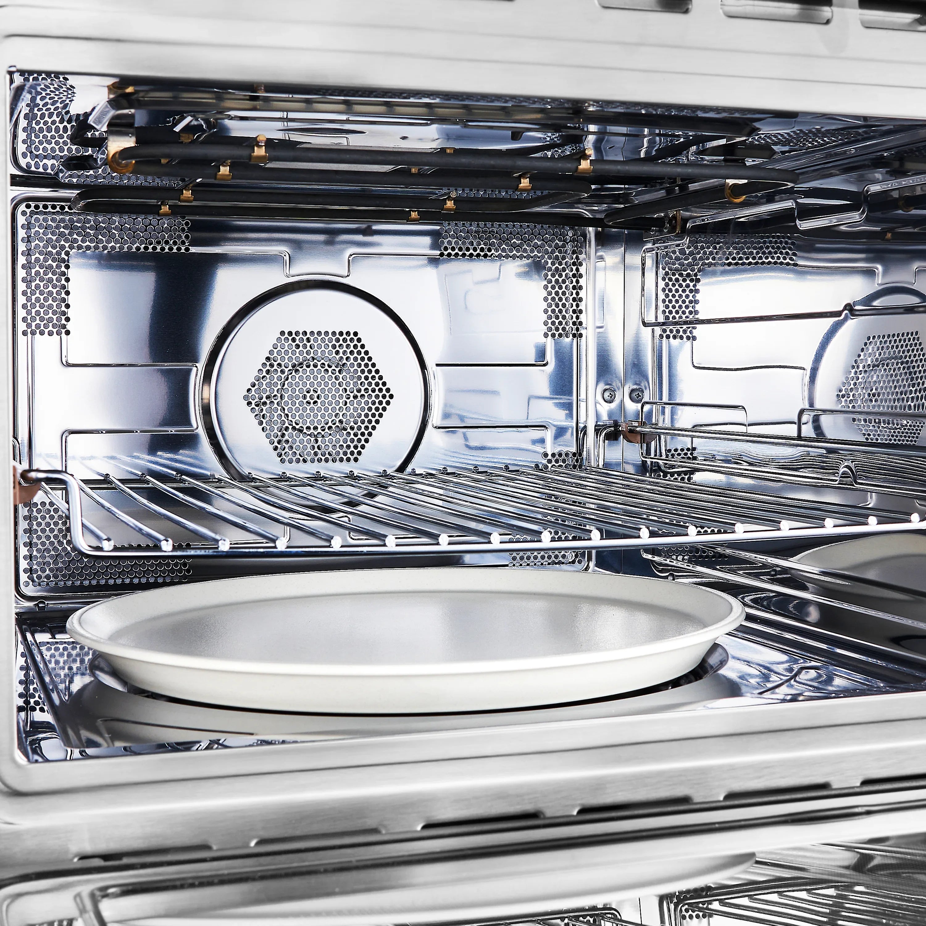 Stainless steel oven interior with circular heating element and upper vents