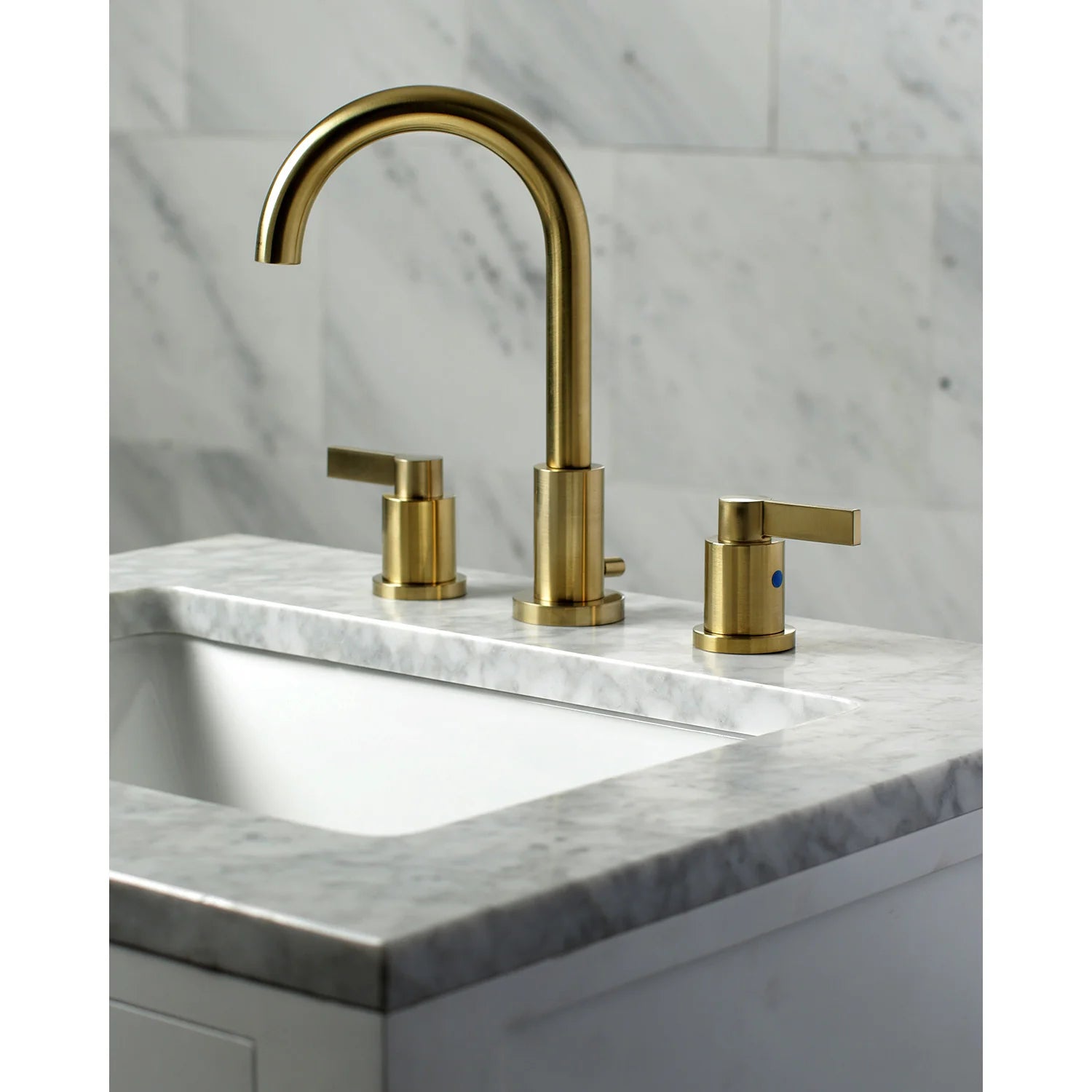 Brushed brass widespread bathroom faucet on countertop with spout and two handles