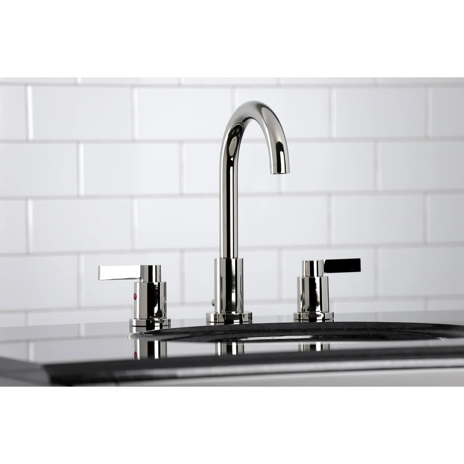 Polished nickel faucet with arched spout and two cross-style handles on countertop