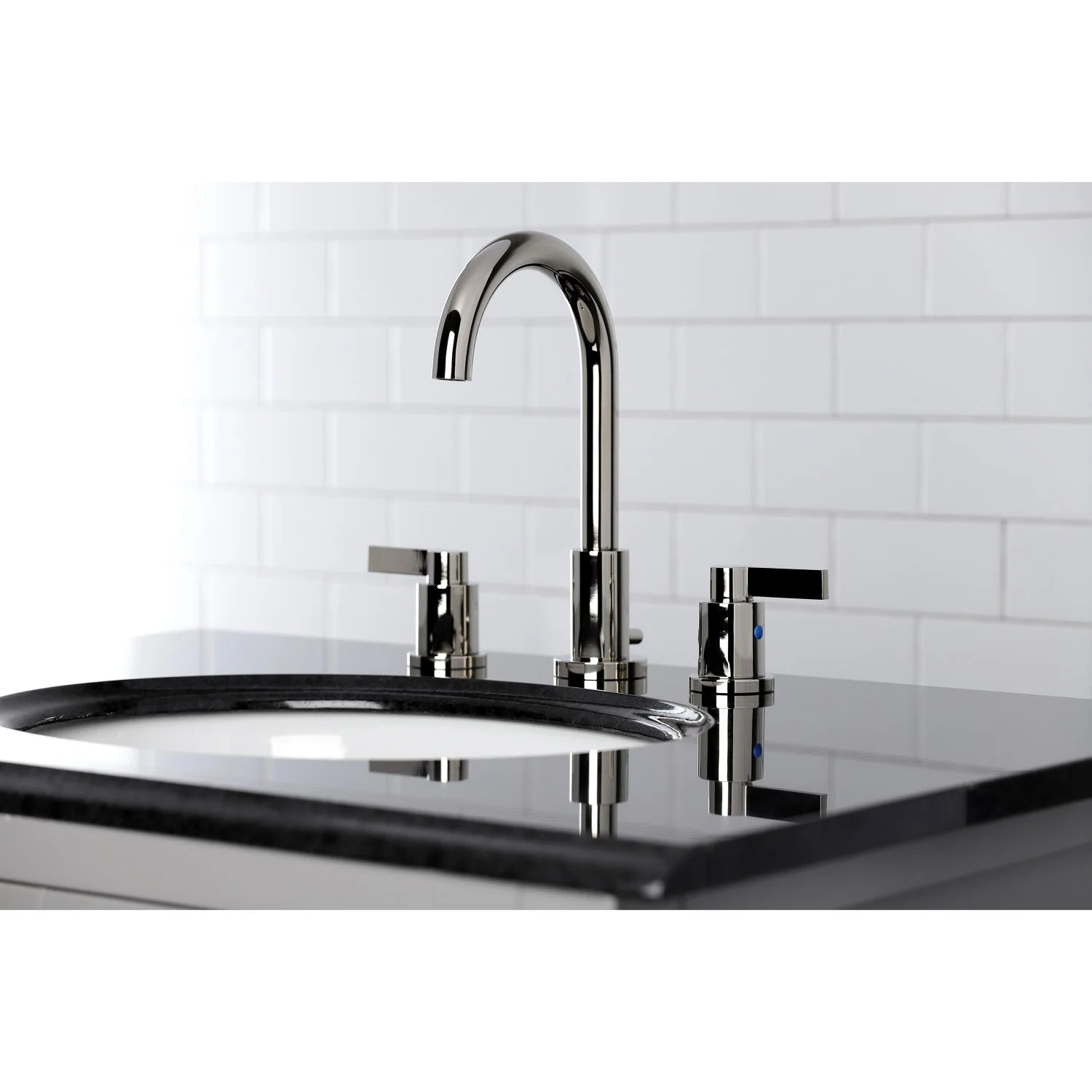 Polished nickel widespread bathroom faucet over a countertop with arched spout and knobs