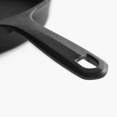 Cast iron skillet handle close-up with loop grip and mounting hole.