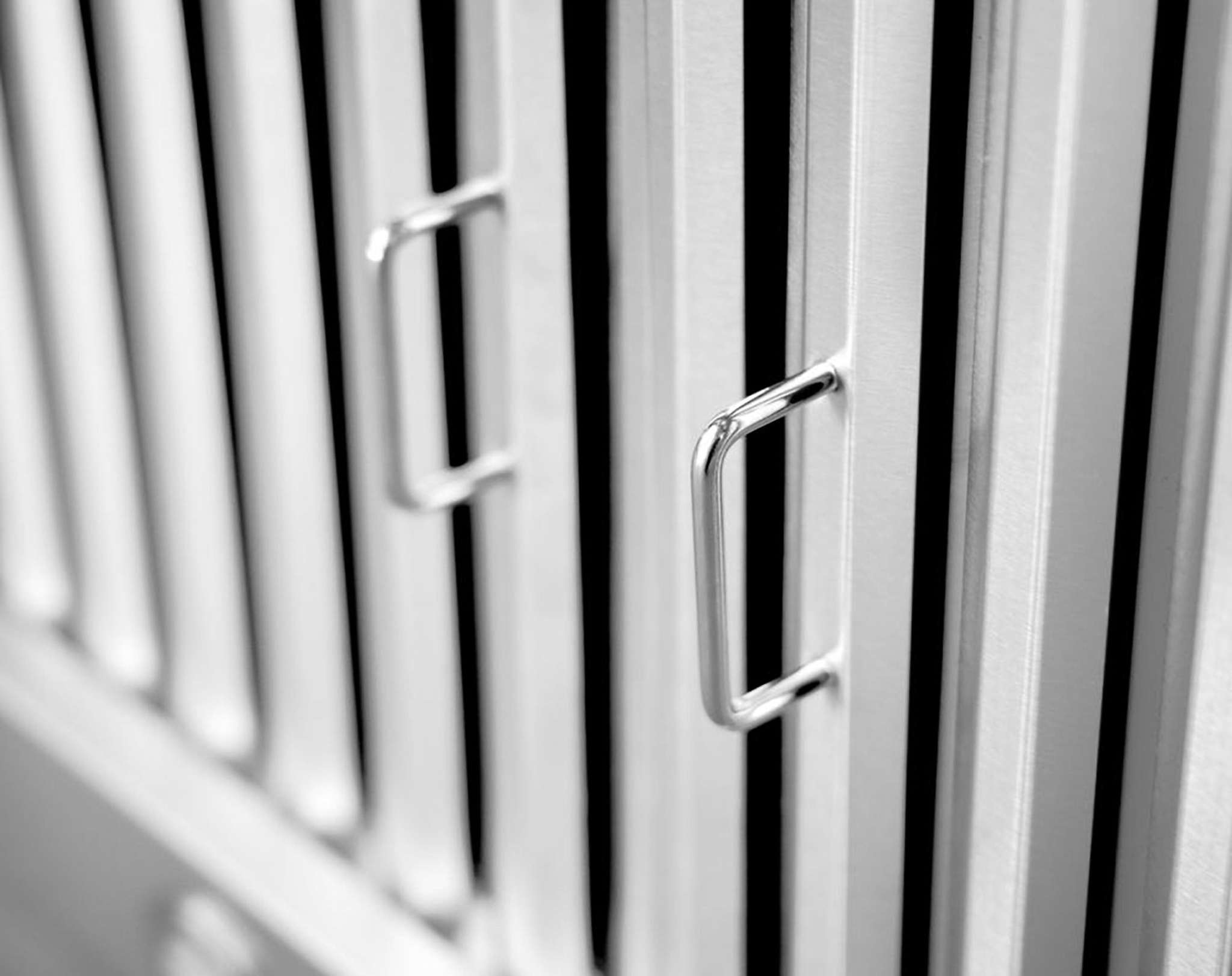 Stainless steel range hood vent grille with metal handle pull, close-up
