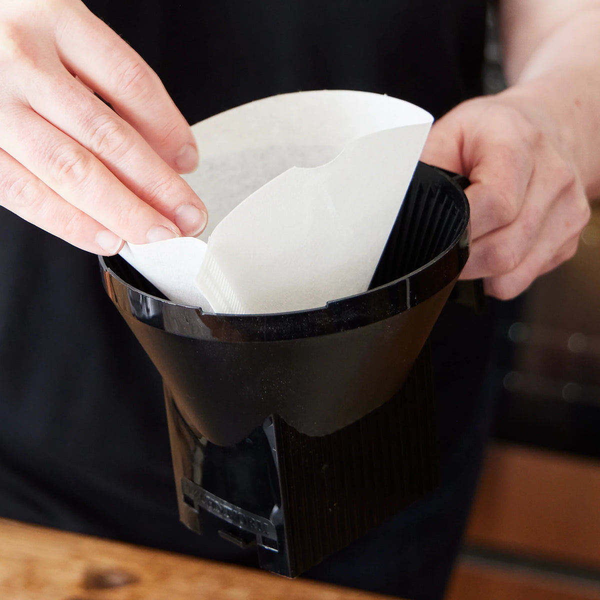 No.4 paper coffee filter being placed into the brewer