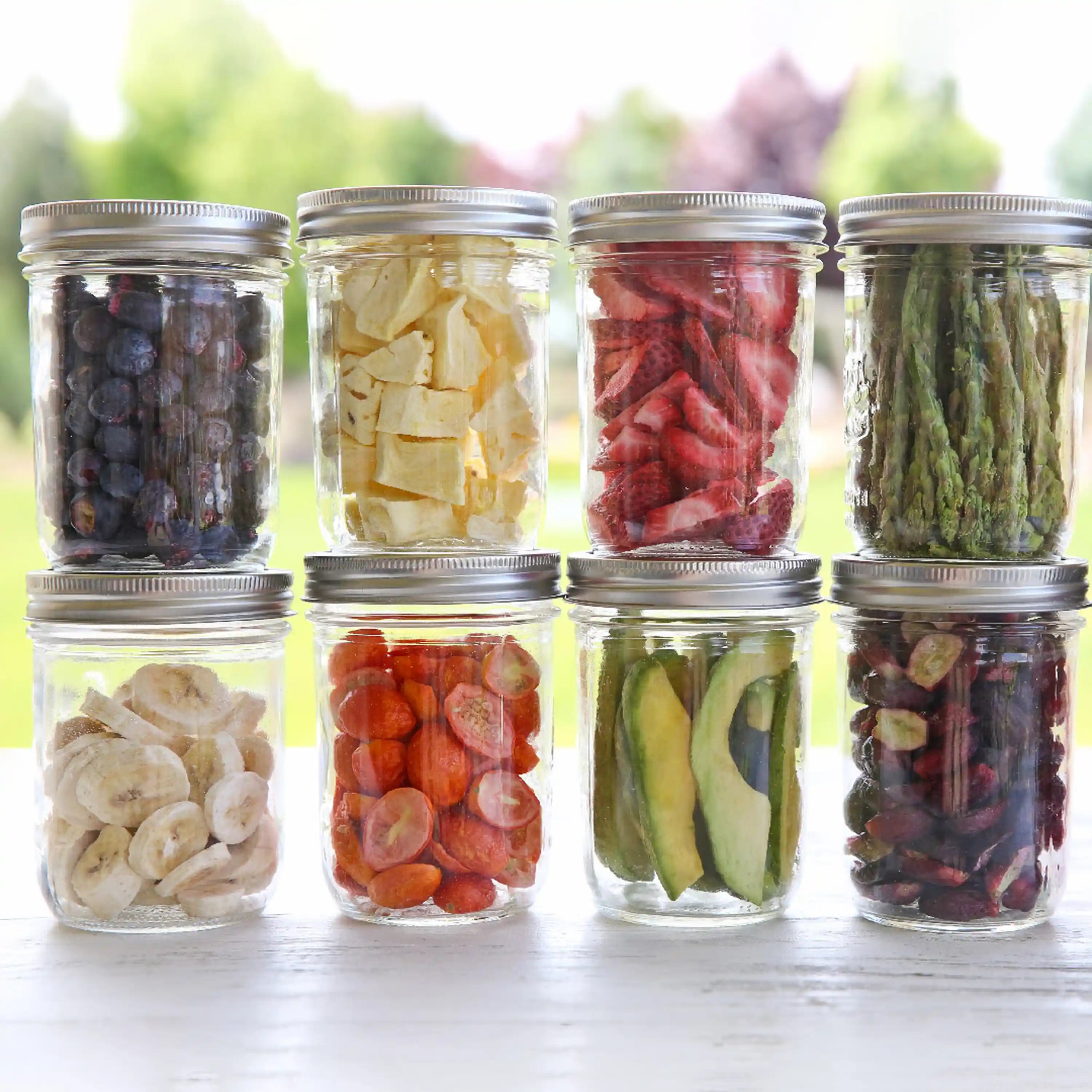 Assorted glass jars of freeze-dried vegetables and fruits with metal lids