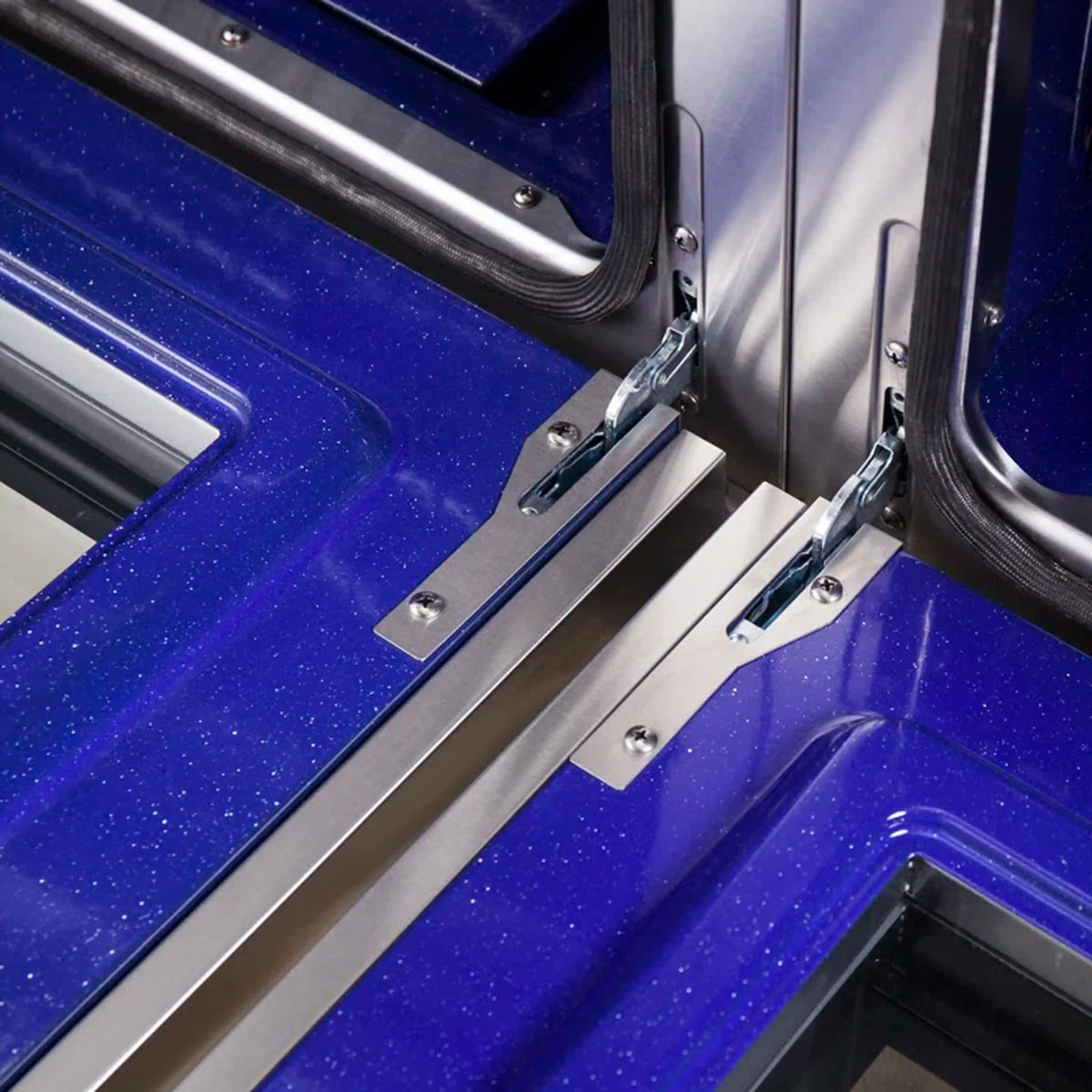 Oven side support rail and seal area over blue enamel base inside stainless frame