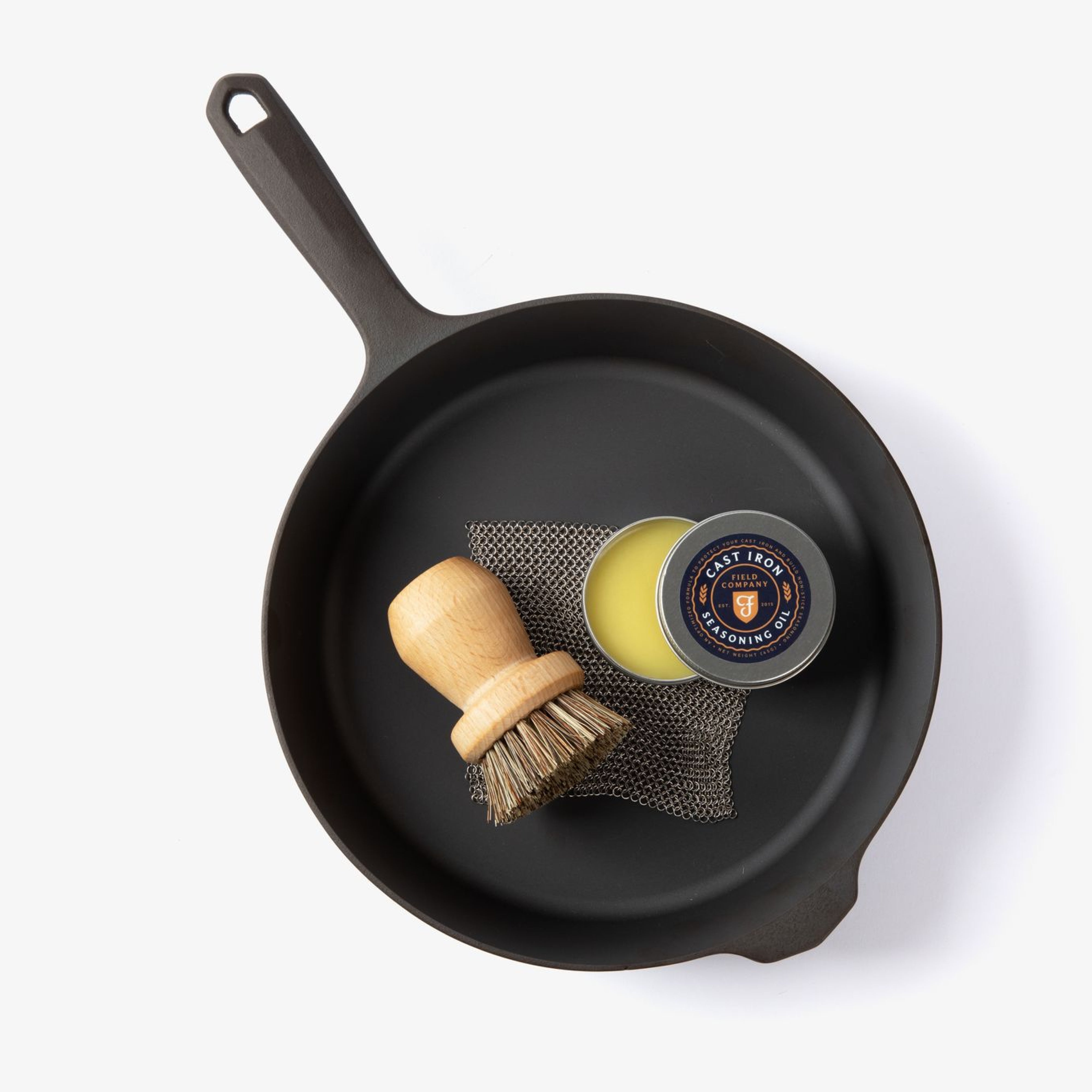 Field Company cast iron skillet with seasoning scrub pad and wooden brush accessory