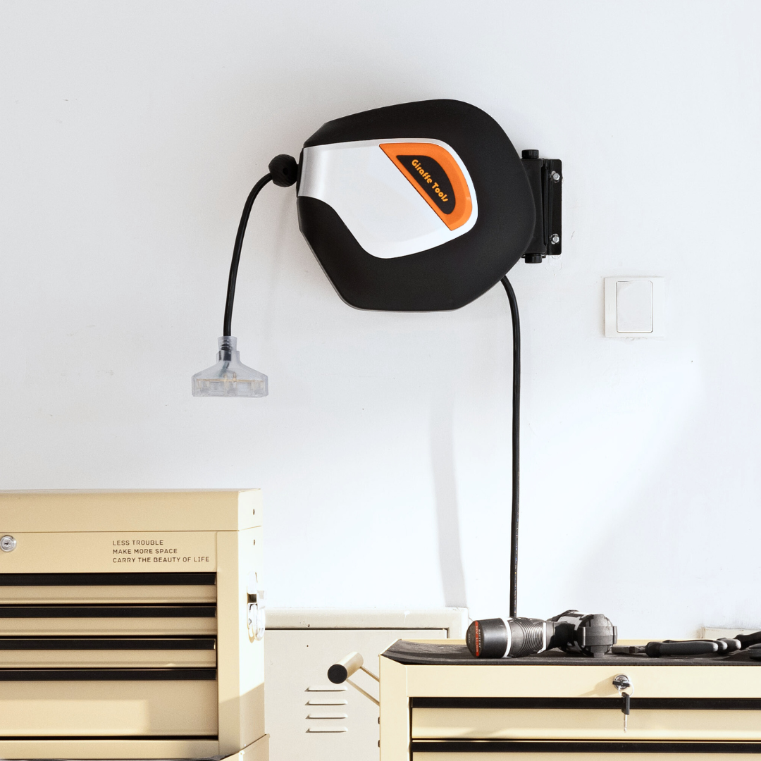 Retractable extension cord reel mounted on wall with cord and plug, black and light gray casing.