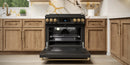 Black gas range with open oven door and bronze-trim control panel