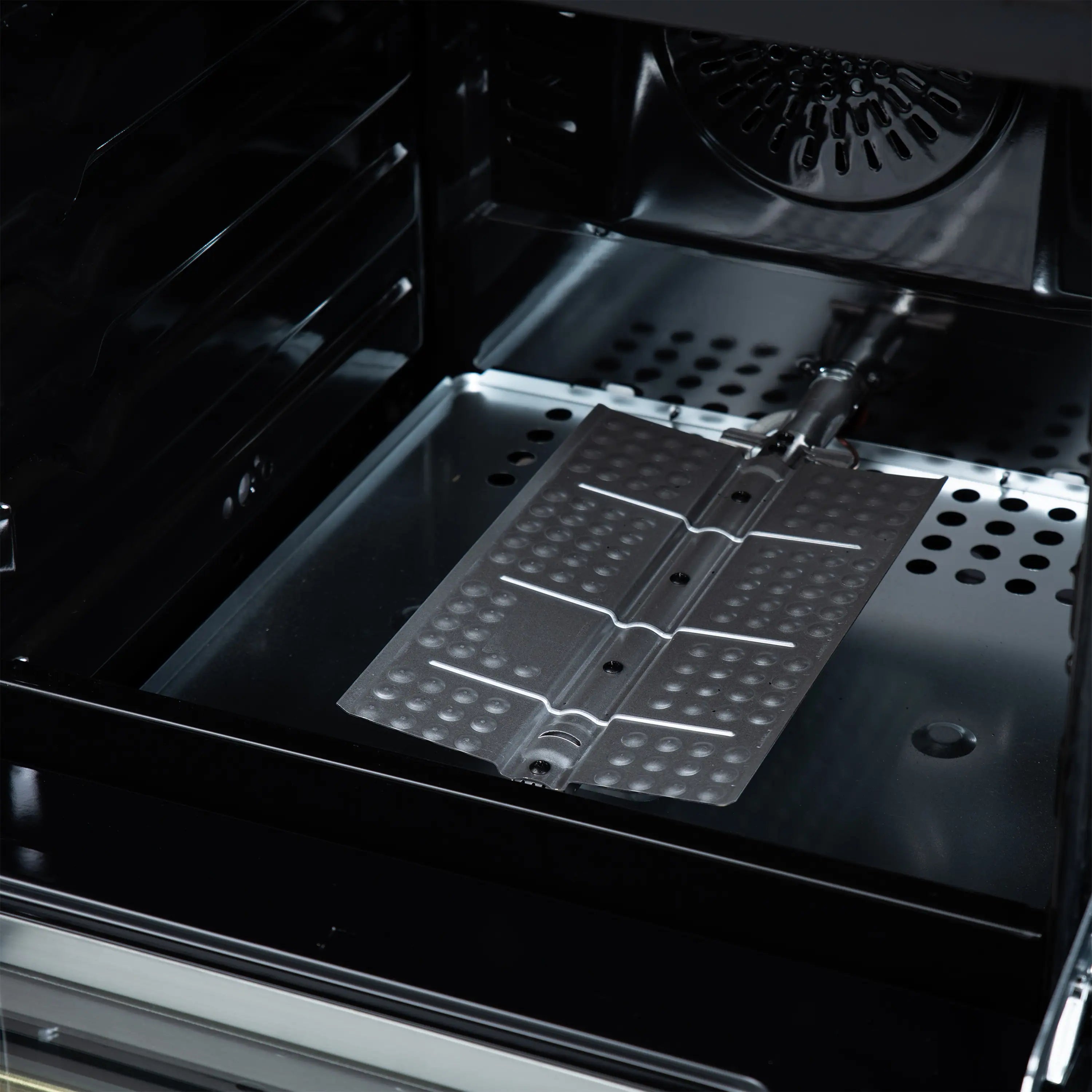 Oven interior of black gas range with perforated racks and heating elements